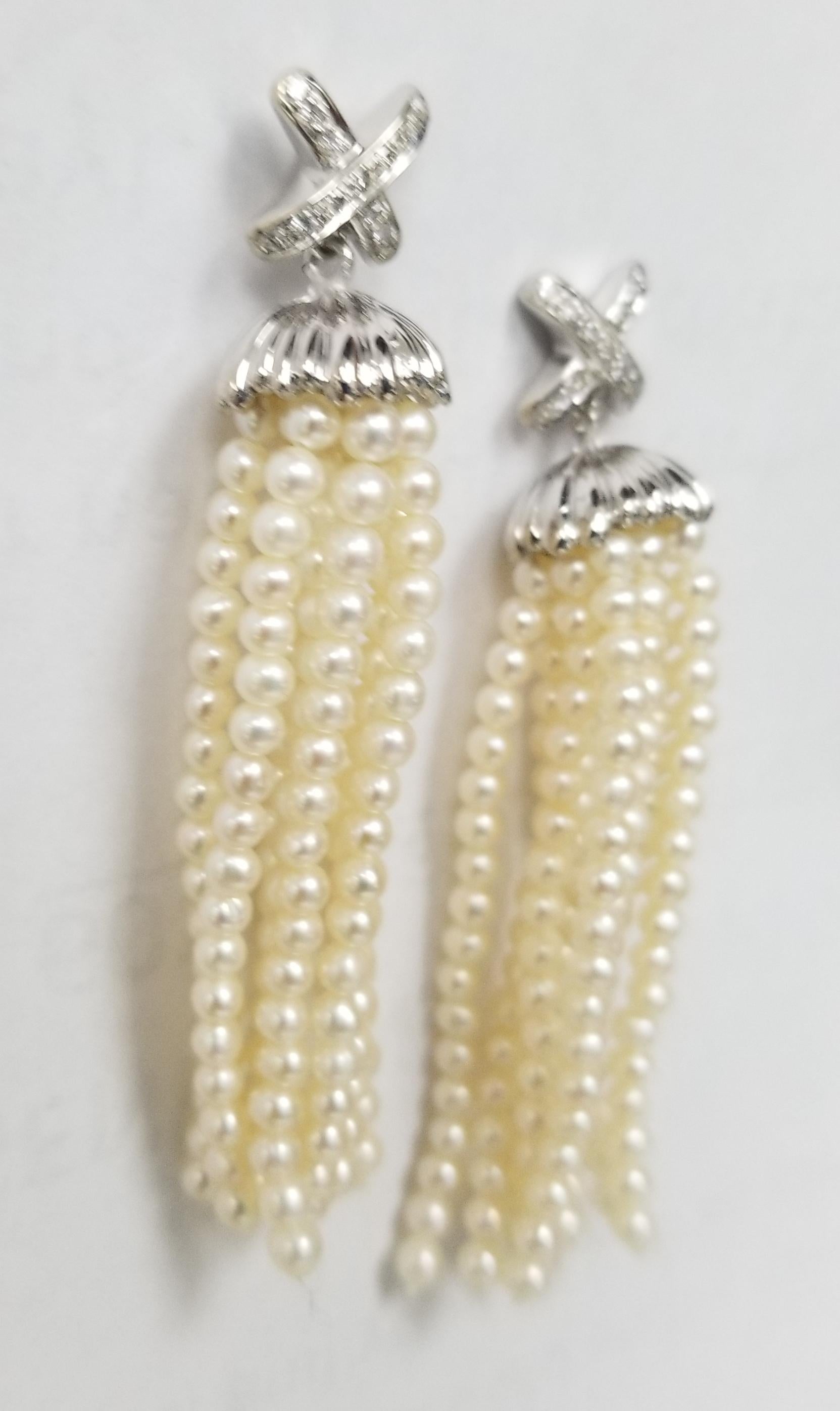 14k white gold diamond and cultured pearl dangle earrings, containing 26 round full cut diamonds weighing .25pts. and inches of 3mm sea pearls dangling from a diamond 