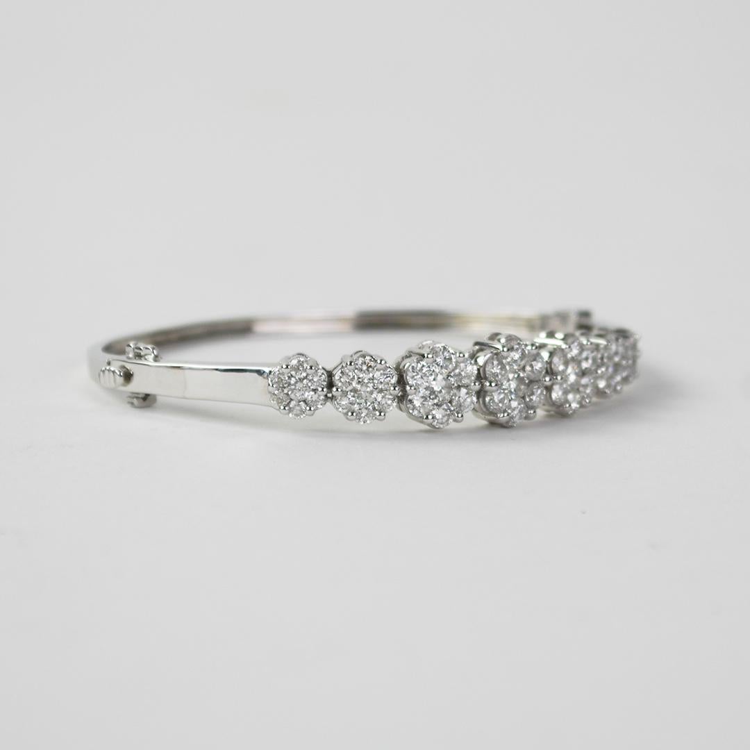 Ladies 14k white gold and diamond bangle bracelet.
Stamped 14k and weighs 16.5 grams gross weight.
The diamonds are round brilliant cuts, 3.50 total carats, G, H, i color range, Si to i1 clarity, good cuts.
The top of the bracelet measures 10mm