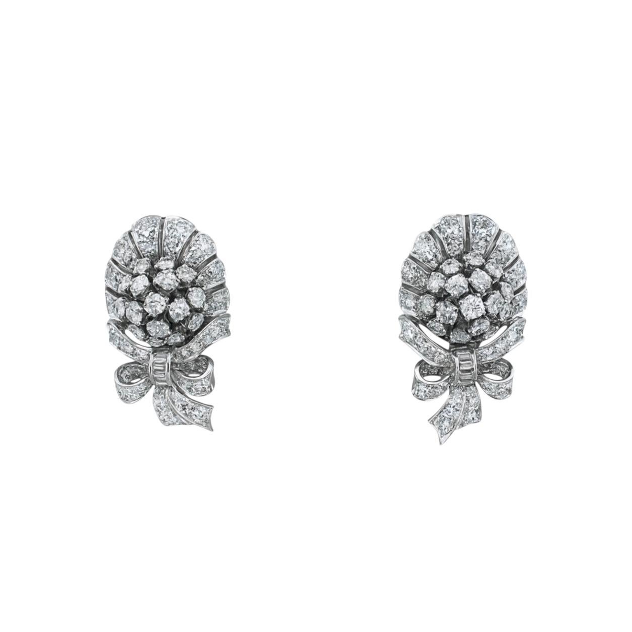 Ein glamouröses Paar Retro-Diamantohrringe aus 14-karätigem Weißgold mit einer bezaubernden Kombination aus Blumen- und Bandmotiven - ein typischer Look der Hollywood-Eleganz der 1940er Jahre.

Jeder Ohrring zeigt eine Gruppe runder Brillanten, die