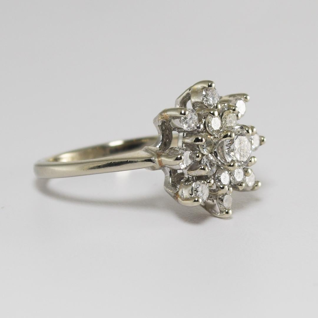 Dieser schöne Ring aus 14 Karat Weißgold wiegt 4,40 Gramm.
Der Diamantencluster besteht aus einem 4 mm großen Diamanten in der Mitte, mit einem Gesamtkaratgewicht von 0,25
Akzentuiert mit siebzehn runden Brillanten, mit einem Gesamtkaratgewicht von
