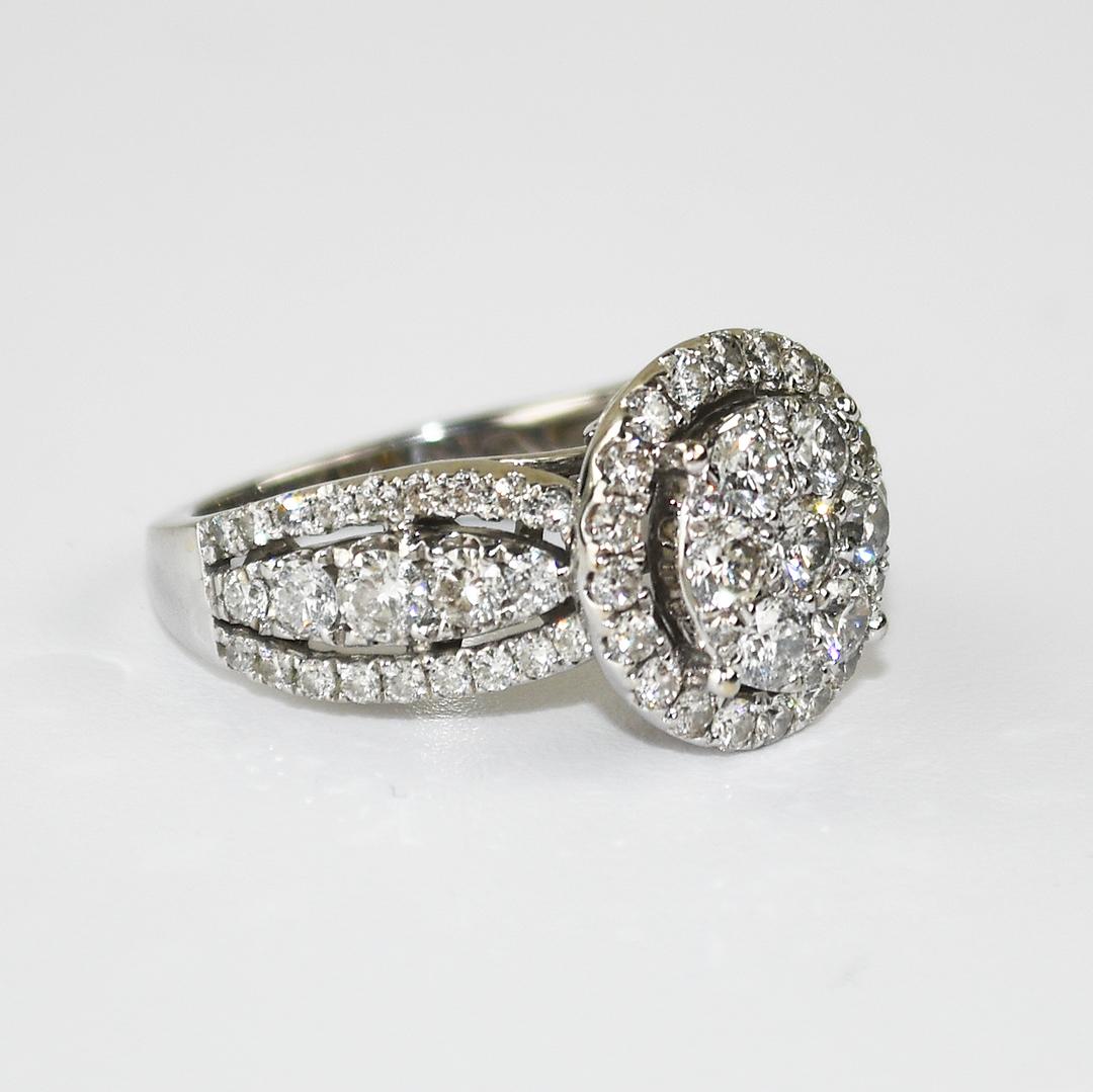 Damenring aus 14-karätigem Weißgold und Diamantcluster.
Gestempelt 14k und wiegt 5,9 Gramm.
Die Diamanten sind rund im Brillantschliff, insgesamt 1,50 Karat, Farbe H bis I, Reinheit Si.
Die Oberseite des Rings ist 12,75 mm breit.
Auf dem Profil des