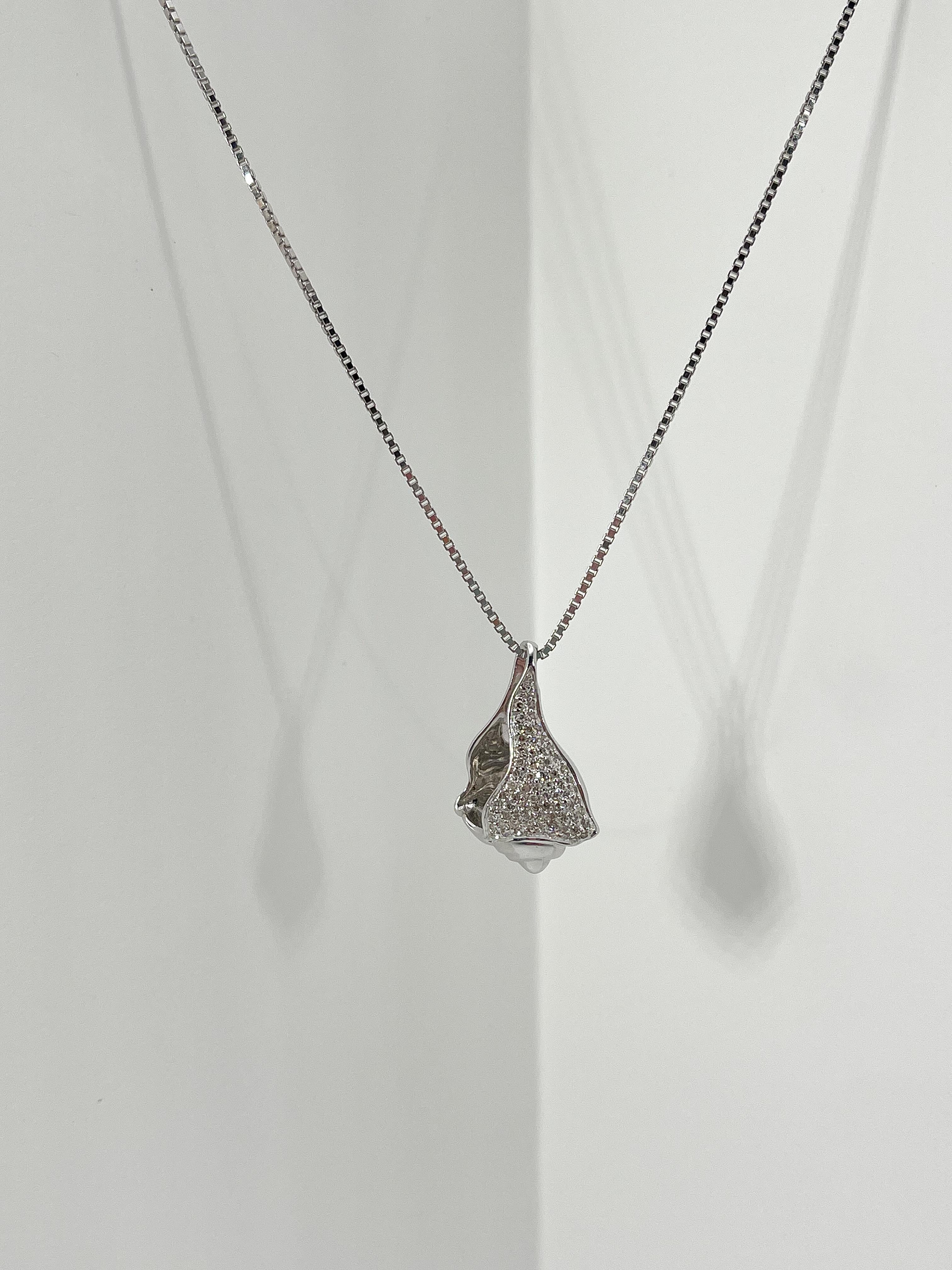 14k white gold diamond conch pendant necklace. The pendant comes on an 18 inch box chain, the pendant measures to be 22mm x 15mm, all diamonds in the pendant are round, has a lobster clasp to open and close, and the necklace has a total weight of
