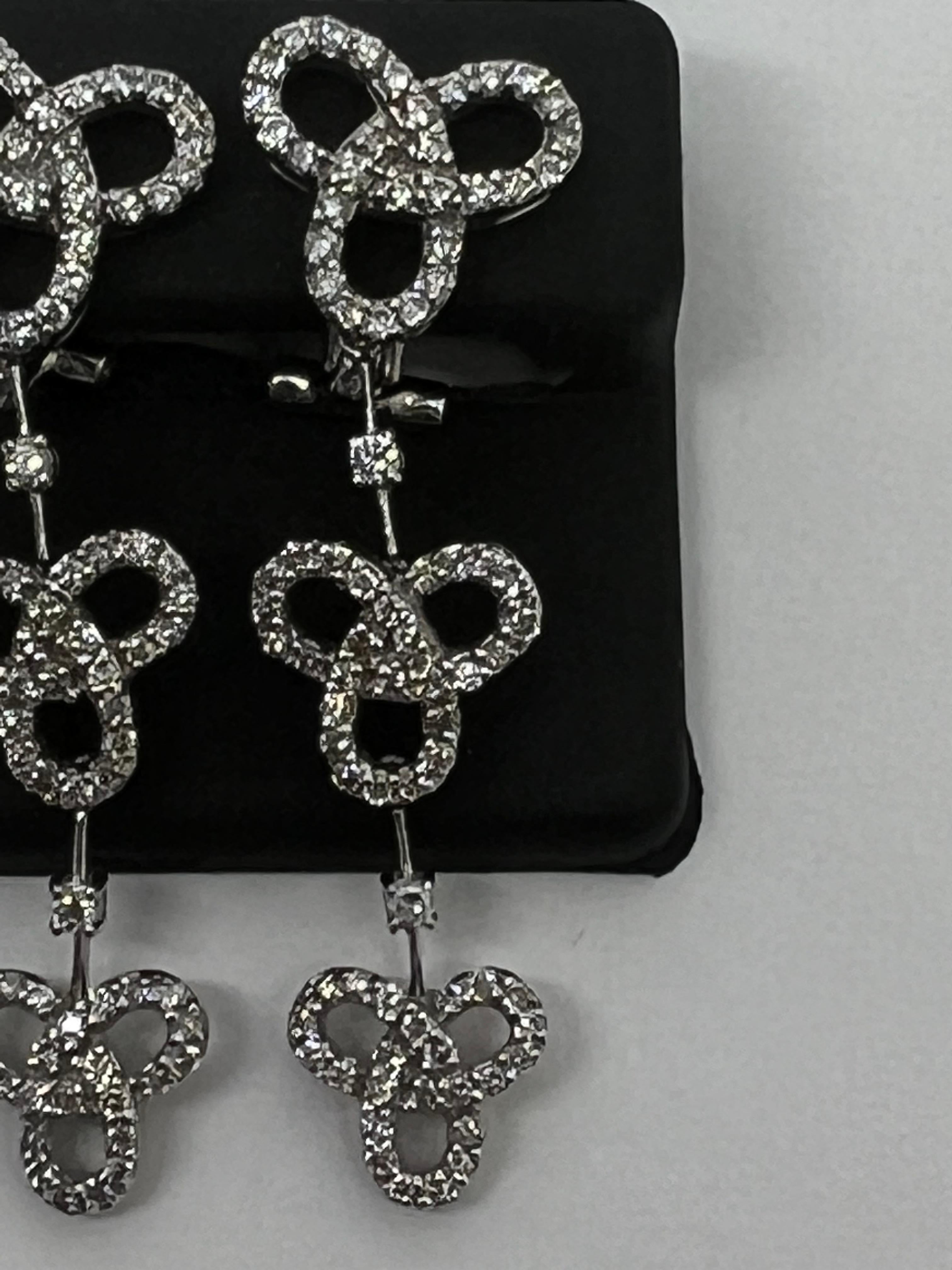 Elevate your style with these stunning 14k white gold diamond dangle drop infinity lever back earrings. Crafted with exquisite attention to detail, these earrings feature a beautiful diamond as the main stone and are perfect for any occasion. The