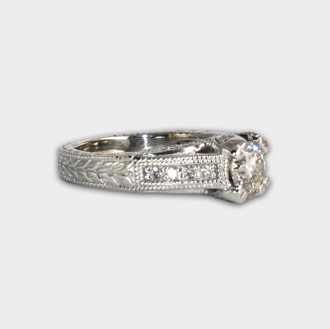 Ladies' diamond engagement ring with 14k white good setting.
Stamped 14k and weighs 6.1 grams gross weight.
The center diamond is a round brilliant cut, .70 carats, J to k color, i1 clarity, and good symmetry.
On the sides are small round accent