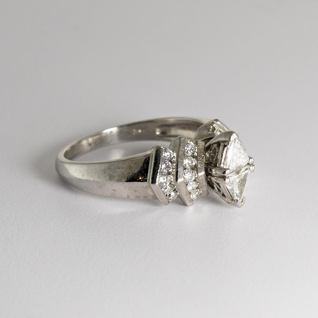 Diamond ring in 14k white gold.
Marked 14k and weighs 5.2 grams.
The two center diamonds are trilliant cut and are set together to look like a marquise-shaped diamond, .50 carats combined.
On the sides are 20 round brilliant cut diamonds
Total Carat