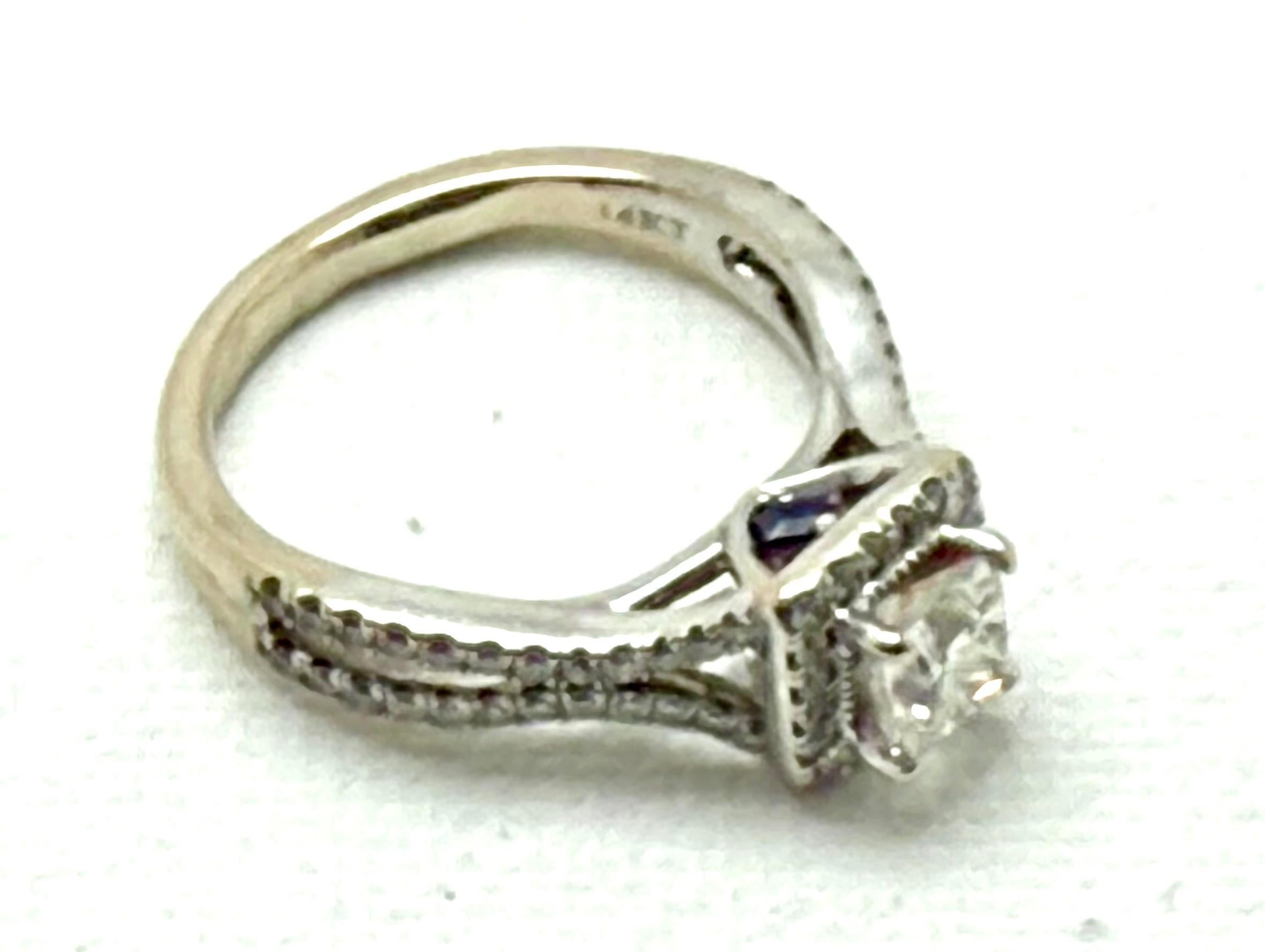 Beautiful 14K White Gold Vera Wang Diamond engagement ring with two small sapphire stones from the Vera Wang Love Collection. The two sapphire stones stand for faithfulness and everlasting love.  4.33 Grams TW. The dimension of the emerald cut
