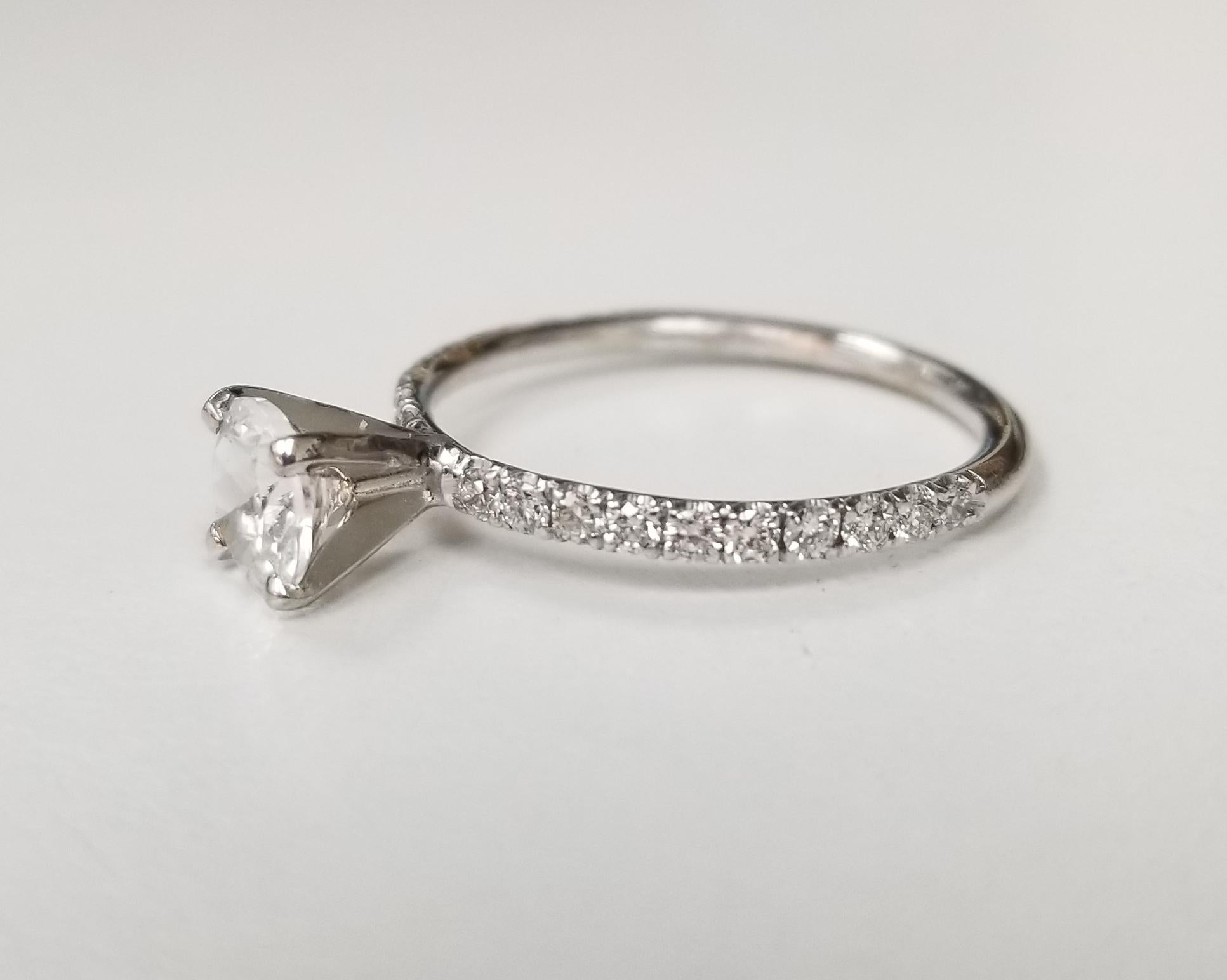 14k white gold diamond engagement ring with white sapphire center containing; 1 5.75mm round white sapphire and 20 round full cut diamonds weighing .30pts. the ring is a size 6.25 and can be sized to fit for free.