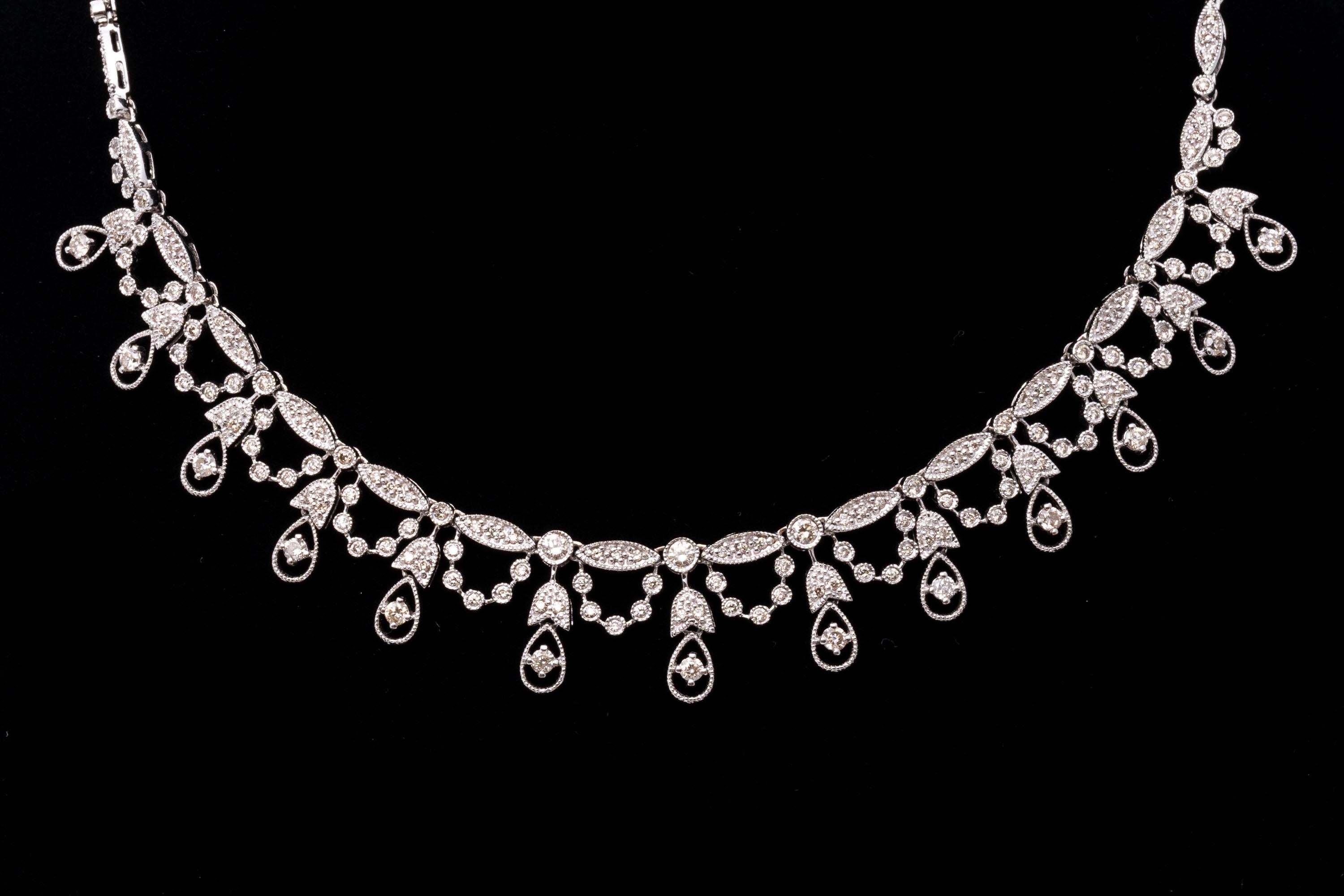 14k white gold necklace. This gorgeous necklace contains alternating oval and round links, milgrain edged and set with round faceted diamonds. The center of the necklace is decorated with tulip topped pear shaped links, alternating with festooned