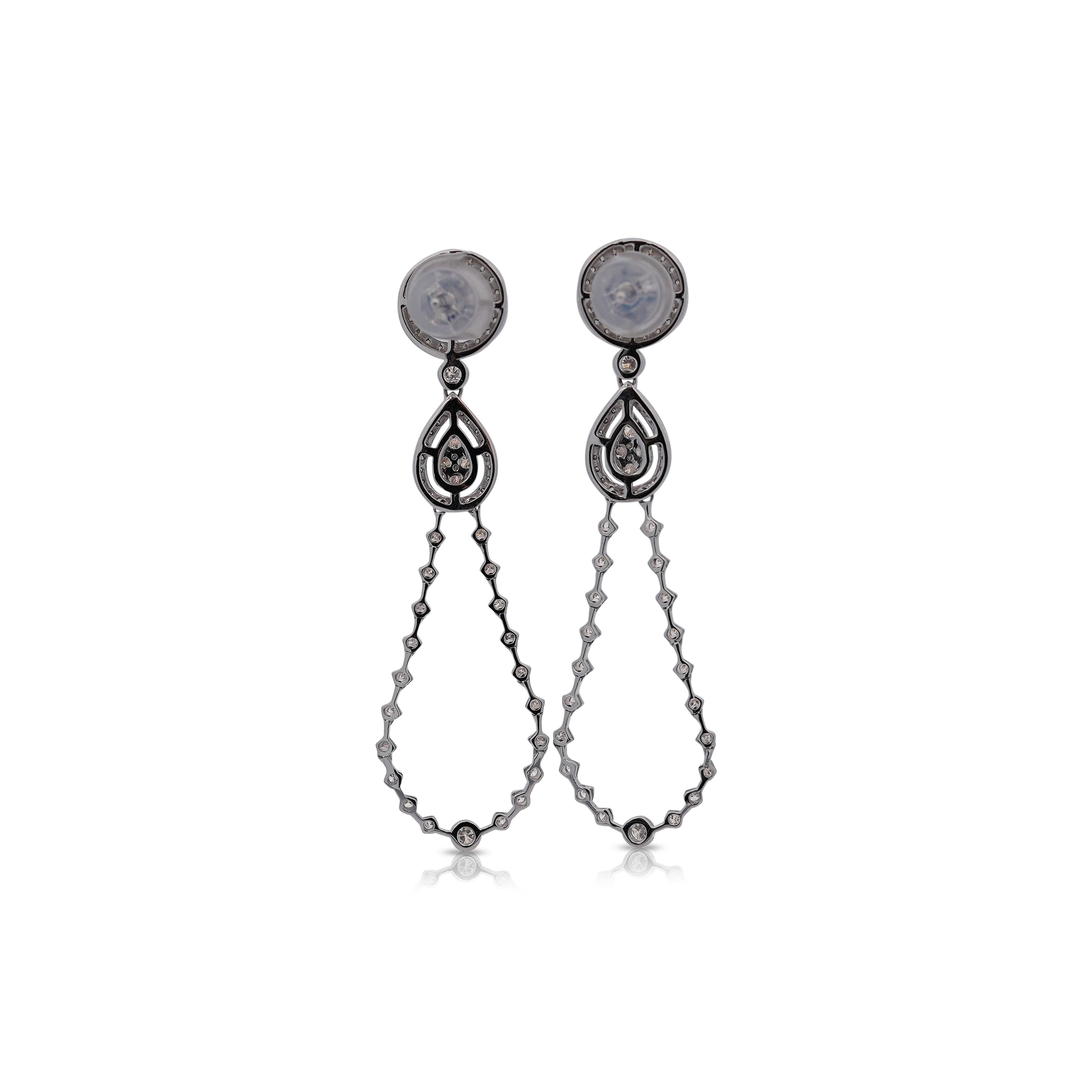 Questi orecchini pendenti in oro bianco 14K presentano una combinazione di diamanti rotondi e baguette per un totale di 1,6 carati. Con diamanti di grado G-H e SI1-SI2.
Un'aureola di diamanti che forma un cerchio con un design a goccia, ha una