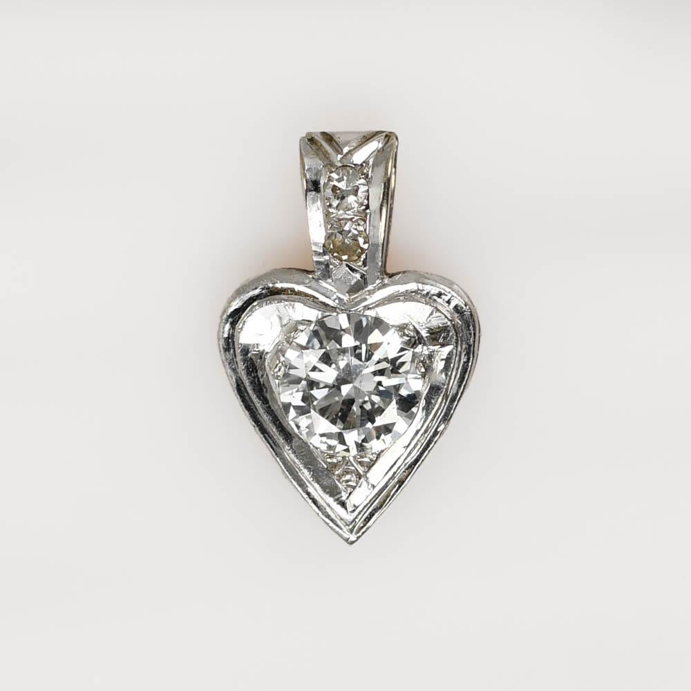 14k White Gold Diamond Heart Pendant, 1gr
The center Diamond is a Round Brilliant Cut, weighing .45ct, SI1-SI2 Clarity, G-H Color.

There are also two smaller single cut Diamonds on the Bail.

Tests 14k, weighs 1gr

