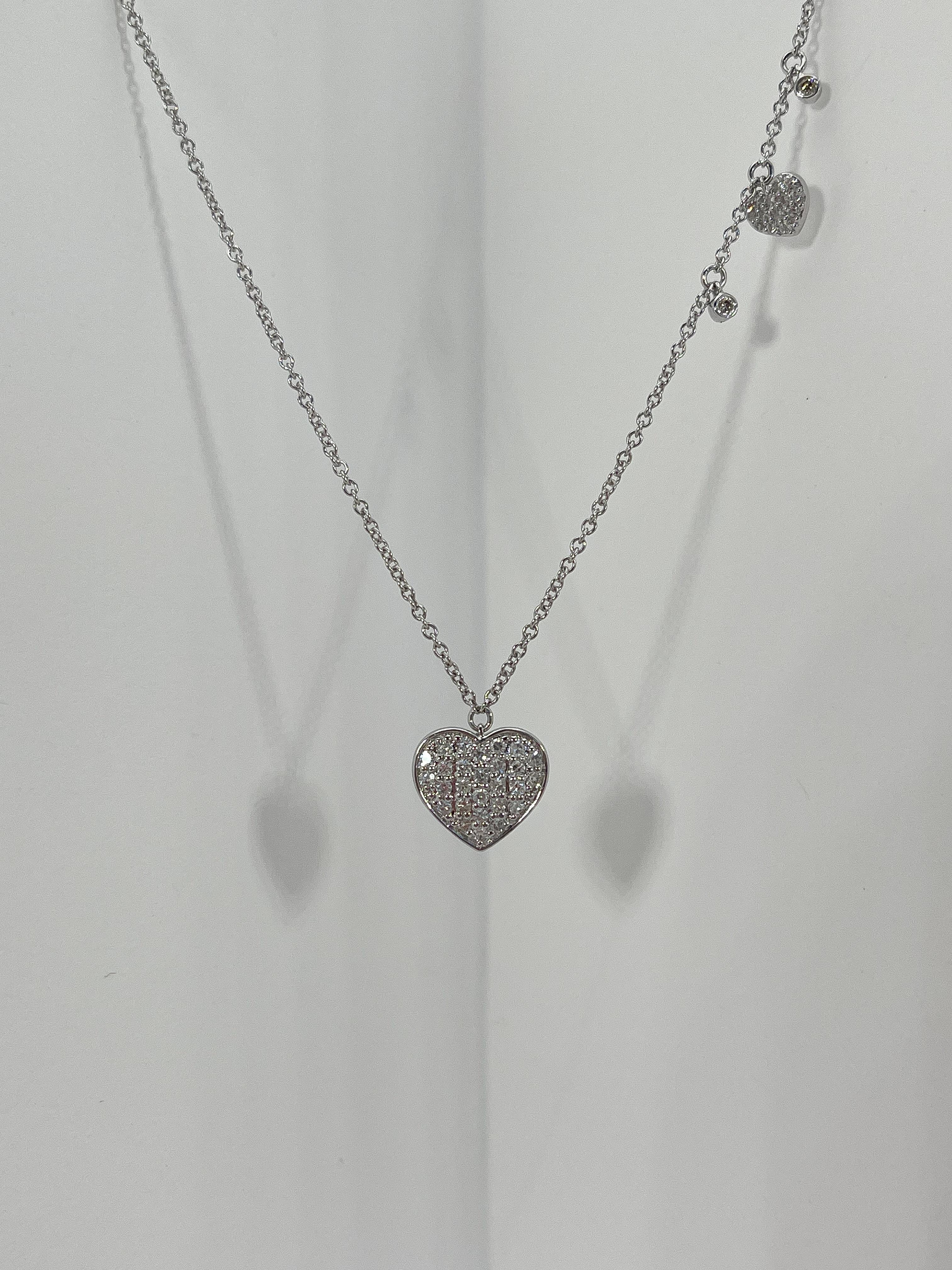 14k white gold diamond heart station necklace. The diamonds in this necklace are all round, the measurements for the pendant are 10.9 x 9 mm, the length of the necklace is 16 inches with an extension to 18'', and the total weight is 3.08 grams