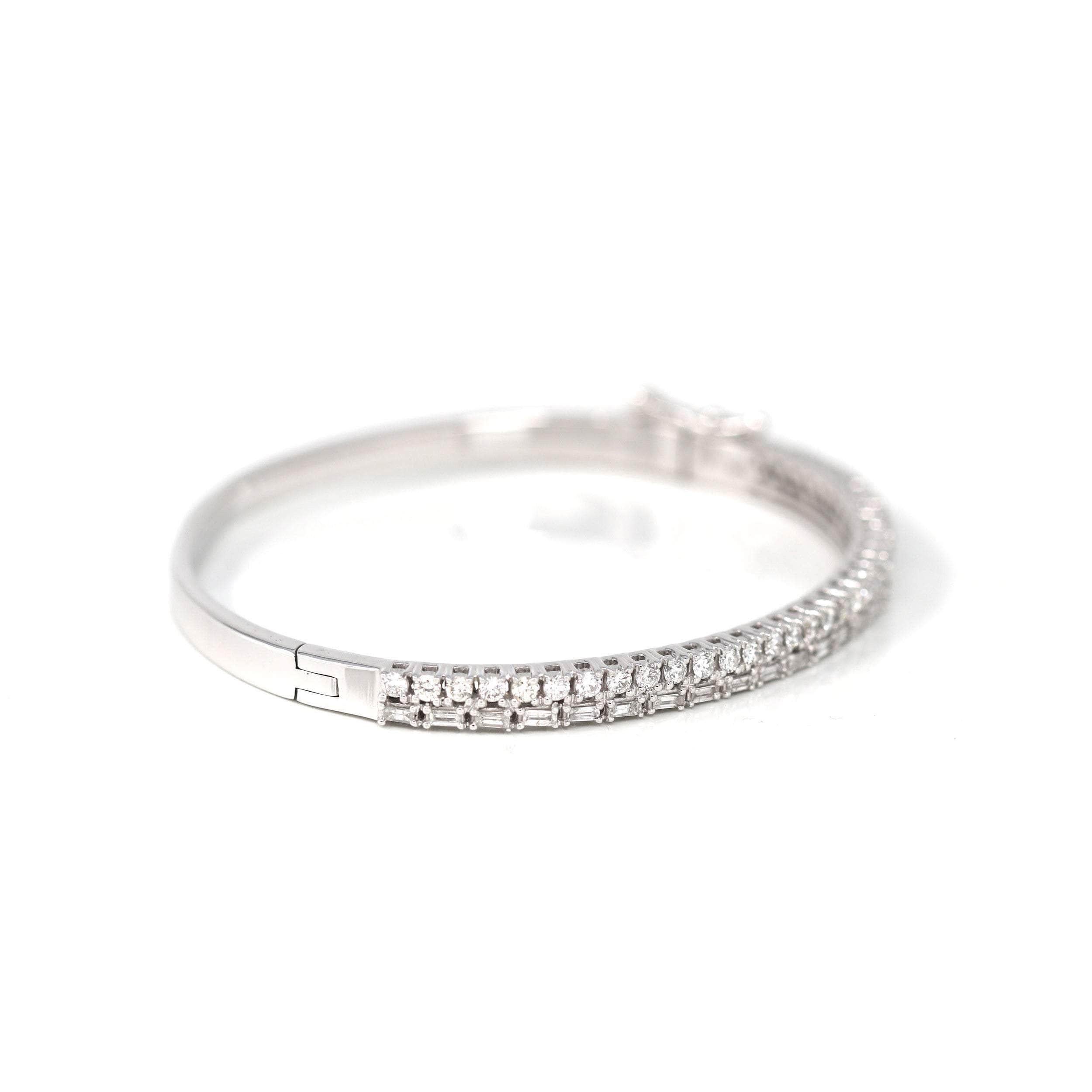 * Design Concept--- She'll love this tennis-look diamond Oval bangle bracelet so much she won't ever want to take it off. Crafted in 14K white gold, this hinged bangle gleams the way around & emerald with shimmering 1.64 ct diamonds in four-prong
