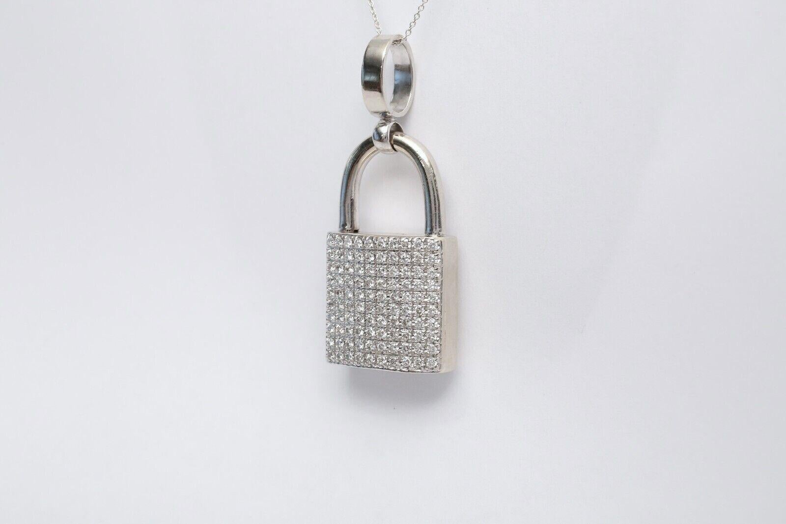 This exquisite 14k white gold padlock pendant is a statement piece of elegance and charm. Adorned with pavé-set round brilliant diamonds, this pendant sparkles with every movement, catching the light beautifully. The intricate grid-like setting