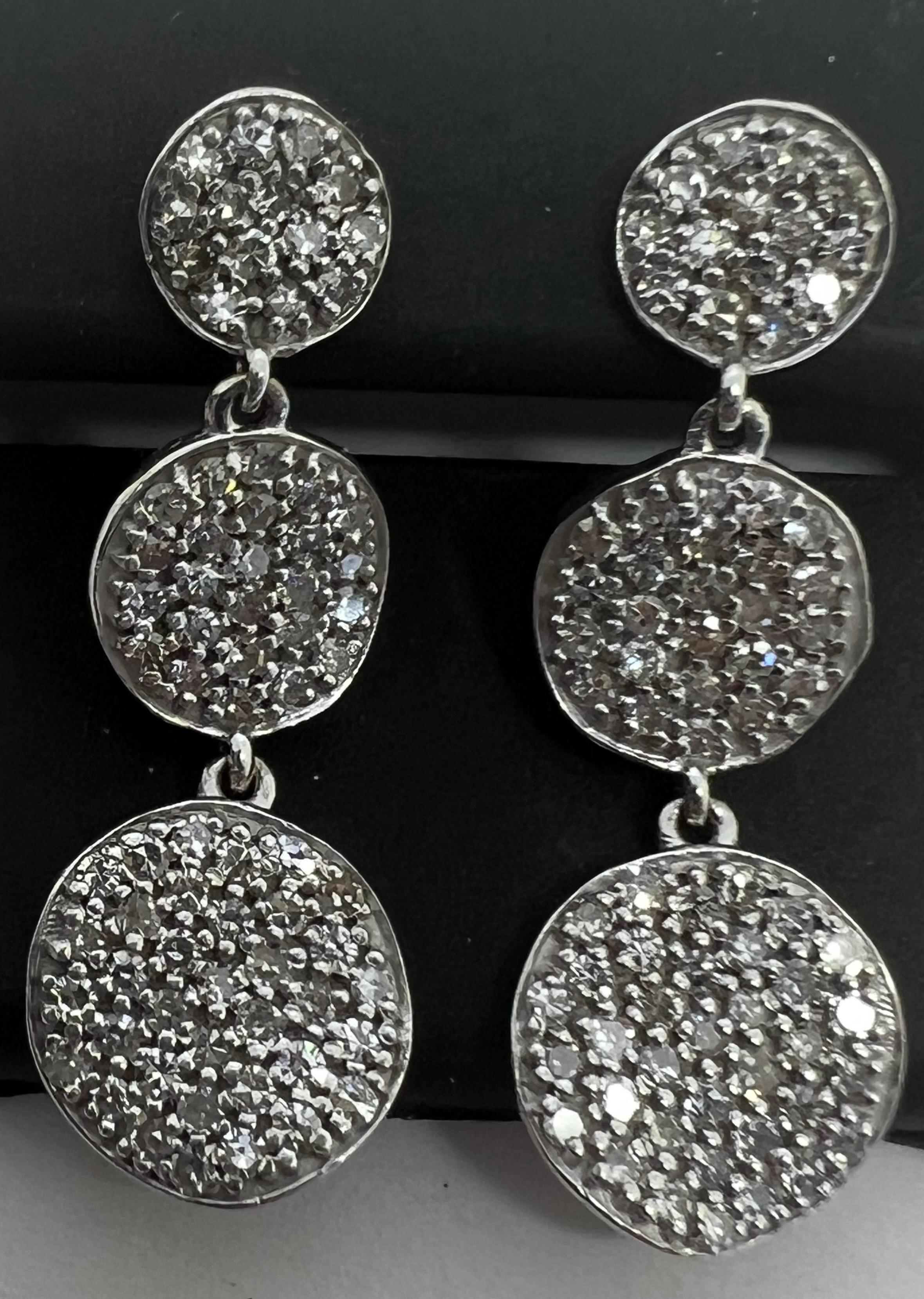 Elevate your style with these exquisite 14k White Gold Diamond Pave Drop Dangle Circle Earrings. The beautiful round shaped natural diamonds are set in a pavé setting style, which gives these earrings an elegant and sophisticated look. The total