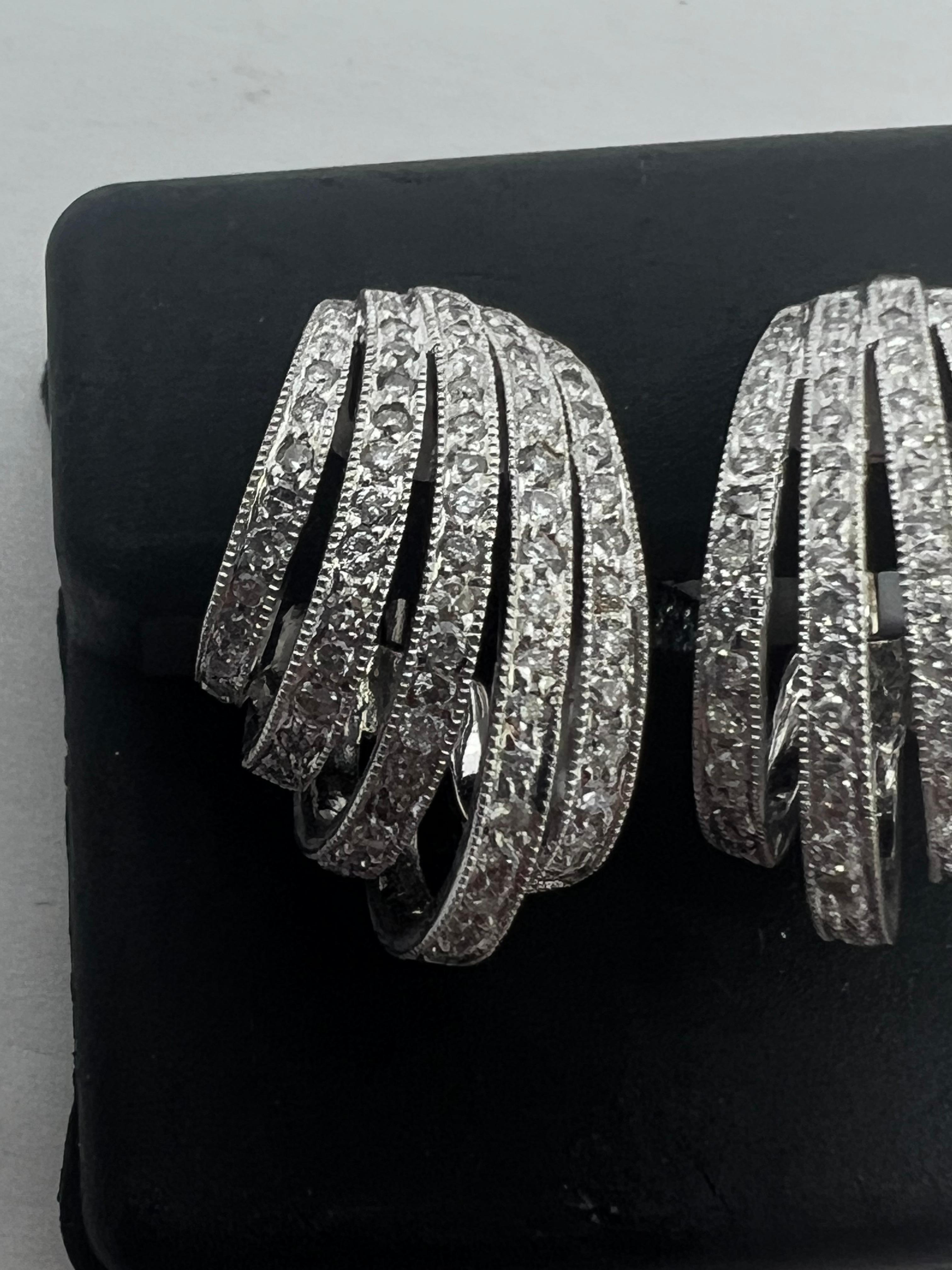 These stunning 14k white gold earrings feature a beautiful pavé setting, dangling from a leaver back shell design. The main stone is a natural round white diamond, set in a yellow gold metal. The earrings are perfect for any occasion and will add a