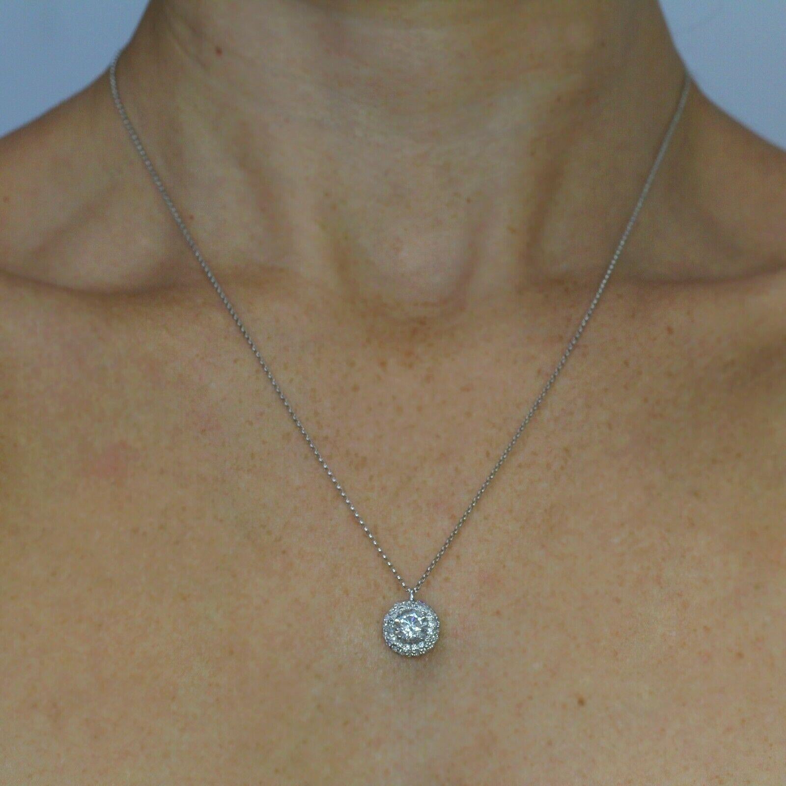 Ce pendentif en diamant est composé d'un diamant rond unique entouré de 3 rangées de diamants micropavés étincelants (environ 0,32ctw, 54ps). La pierre centrale est de 1.03ct  Diamant E SI3. Ce magnifique collier en or blanc 14k mesure 18