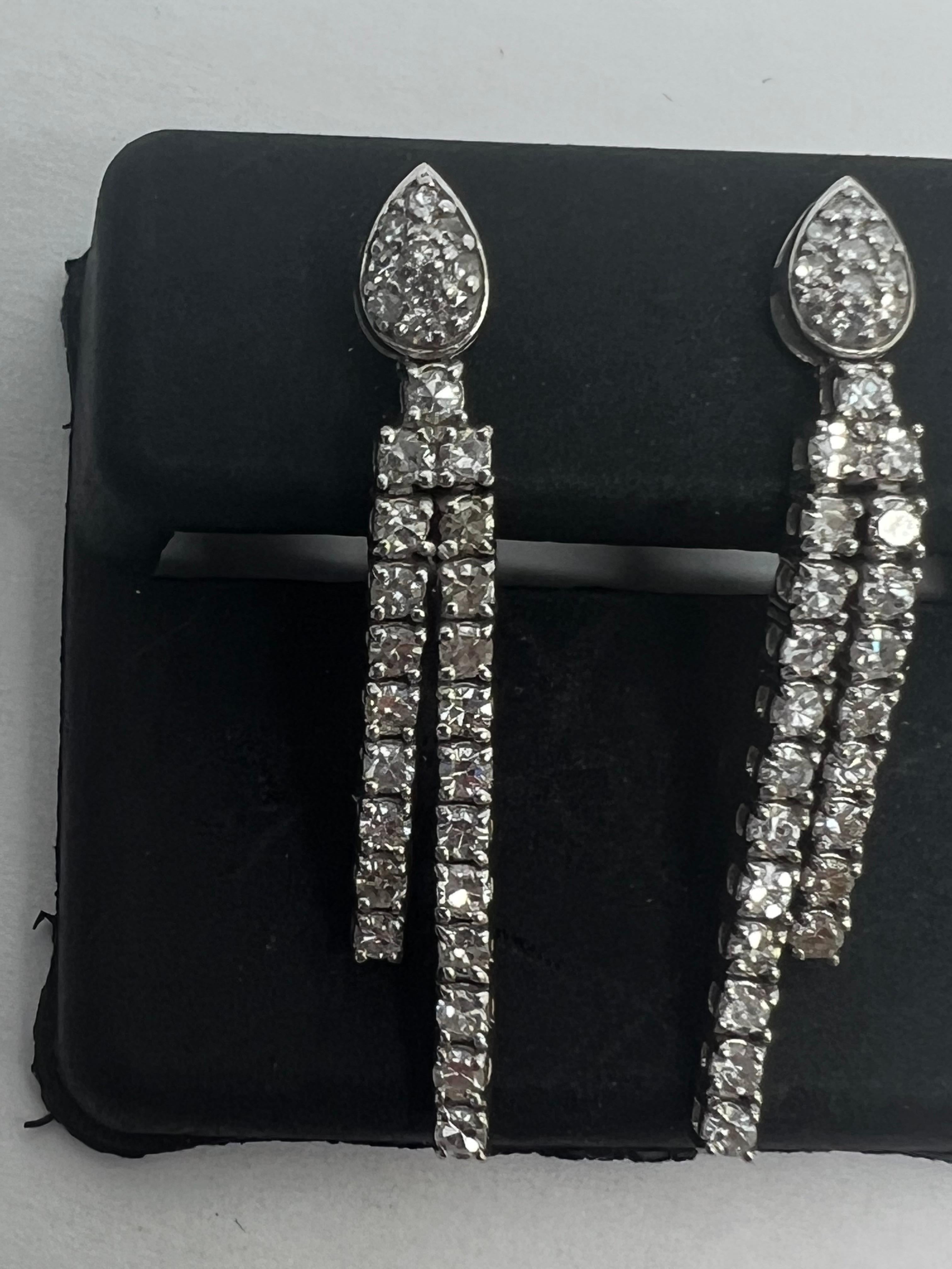 Add a touch of elegance to your outfit with these stunning 14k White Gold Diamond Pave Prong Drop Dangle Pear Earrings. The teardrop shape with a round diamond at the center adds a natural and timeless beauty to its design. The prong setting style