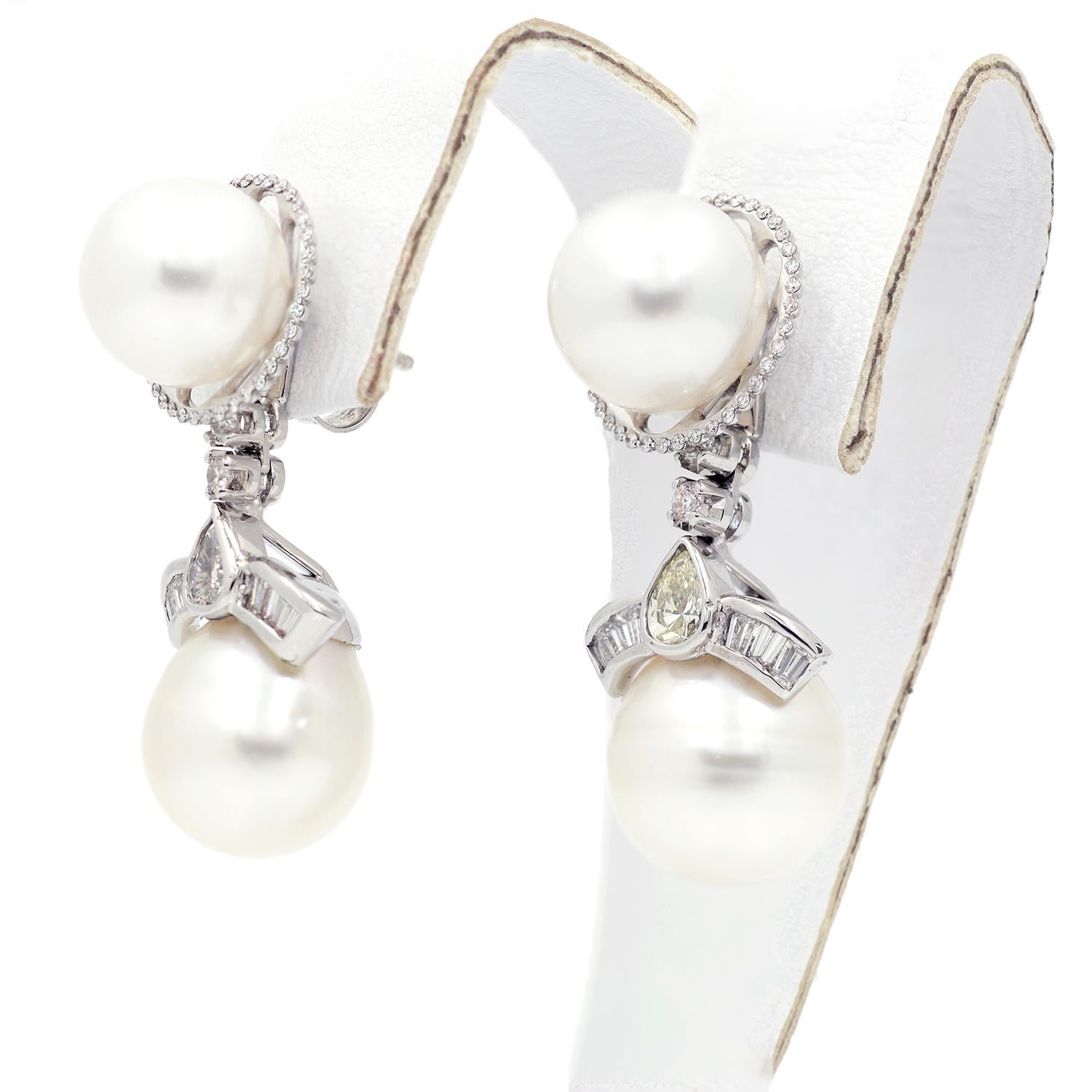 These 14 karat white gold earring jackets feature South Sea pearls accented with two round diamonds, six tapered baguette diamonds, and two pear shaped diamonds. The pearls measure approximately 12.75mm in diameter, and the diamonds weigh an