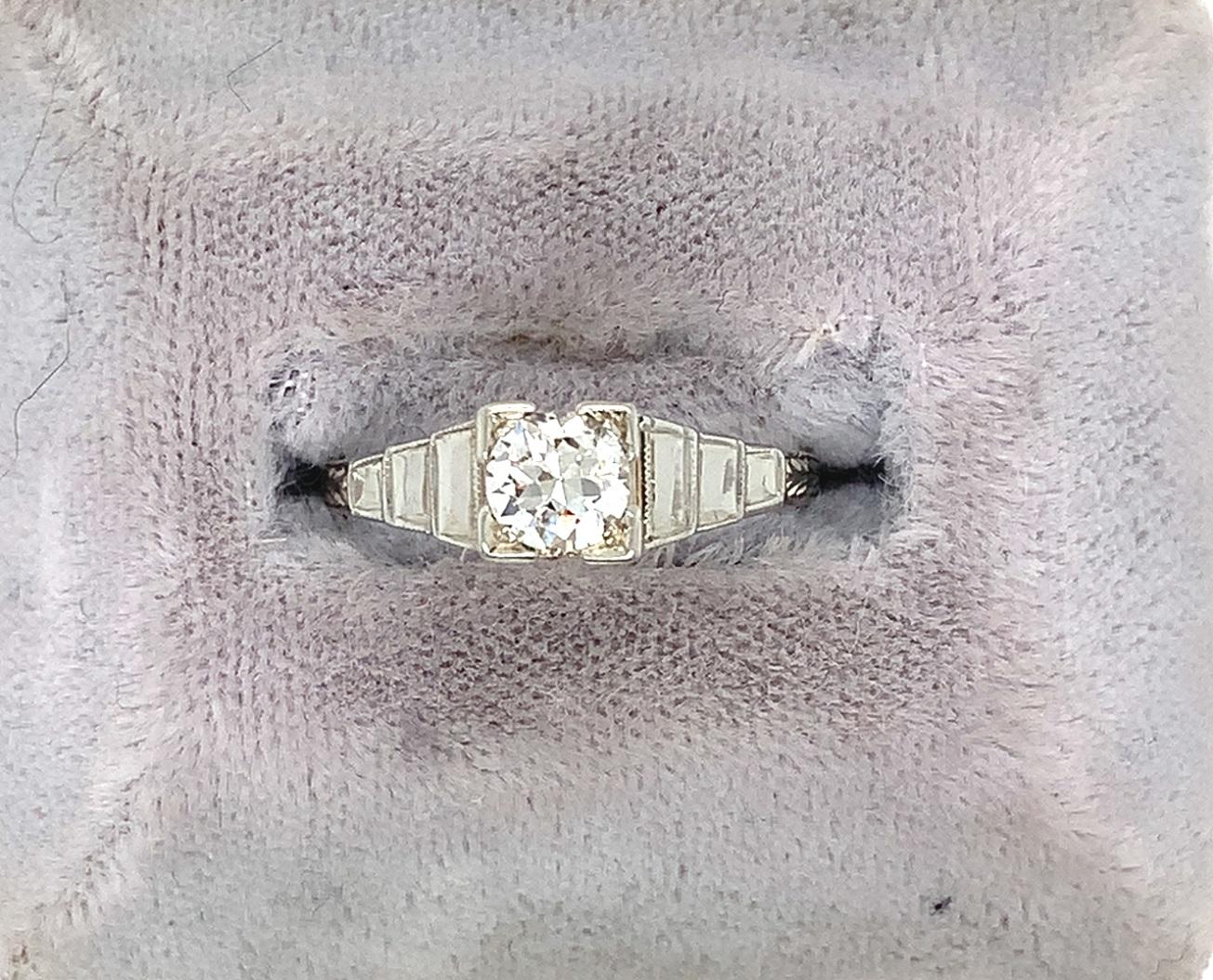 Anello in oro bianco 14K con diamante taglio europeo del peso di circa 0,45 carati. C'è un disegno a gradini e foglie inciso a mano. Il diamante misura 4,9 mm e presenta una purezza VS-2 e un colore I-J.  L'anello veste una misura 6 3/4, pesa 1,58