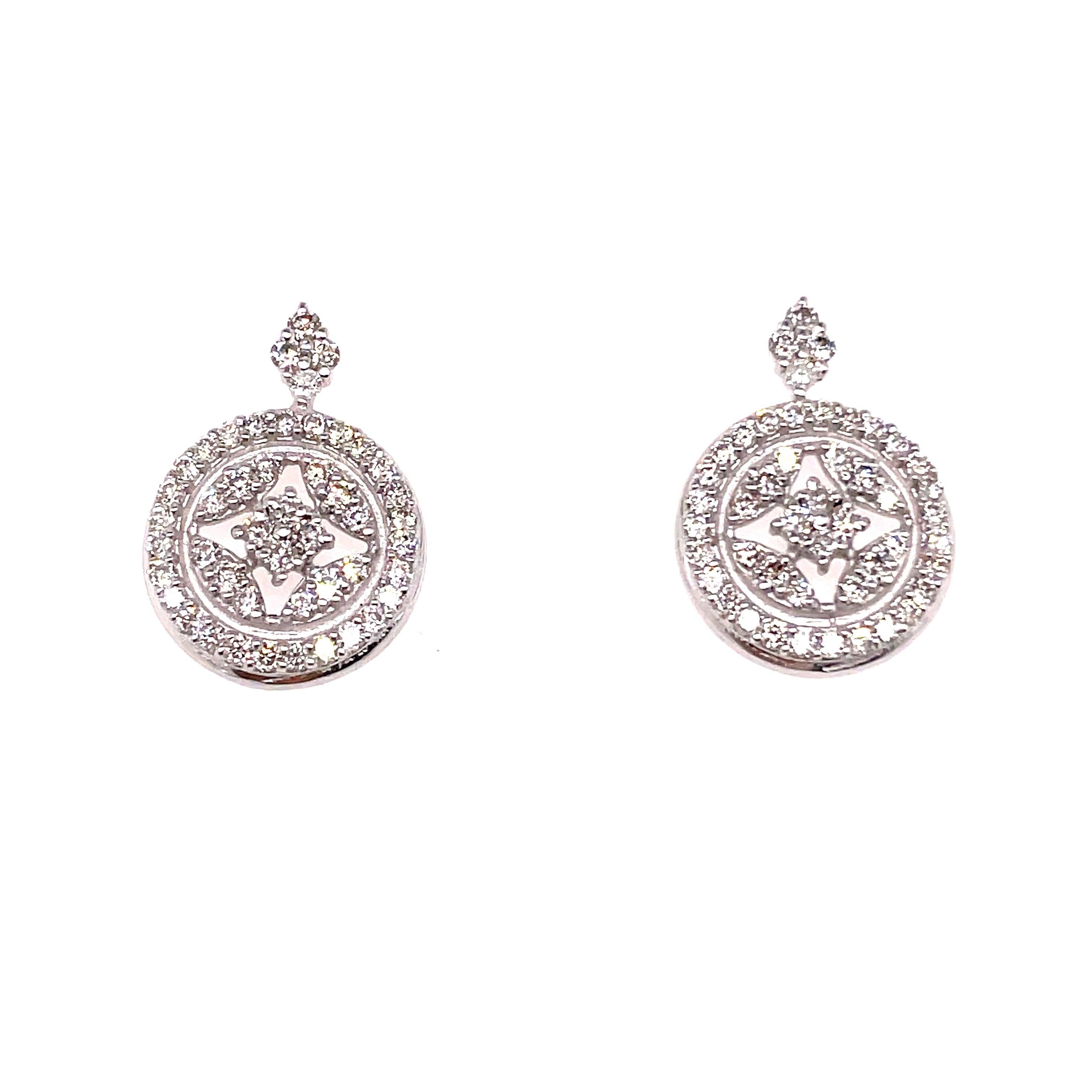 Le design en forme de diamant méticuleusement élaboré, orné d'un pavé rond de diamants exquis, qui l'enveloppe, crée un jeu de brillance envoûtant, capturant l'essence de l'élégance sous toutes ses facettes.

Les diamants qui entourent les boucles