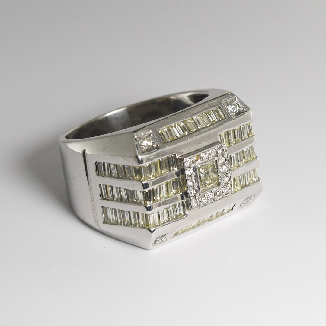 Dies ist ein 14k Weißgold Männer Siegel Stil Ring.
Dieser Ring enthält 3,30 Karat baguettförmige Diamanten in Kanalfassung und 0,15 Karat runde Brillanten in Zackenfassung.
Der Hauptstein ist ein 0,30 Karat schwerer Diamant im Prinzessinnenschliff