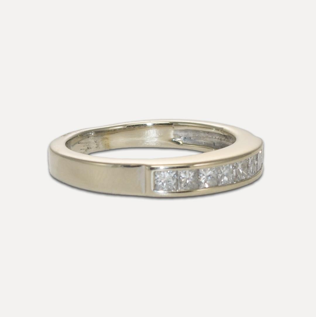 Fascia nuziale con diamante in oro bianco 14k.
Pesa 3,60 grammi.
Contiene otto diamanti taglio princess, con un peso totale di 0,80 carati, purezza SI2 e colore H.
Ogni diamante è montato in una montatura a canale.
Misura 3,5 mm di larghezza ed è