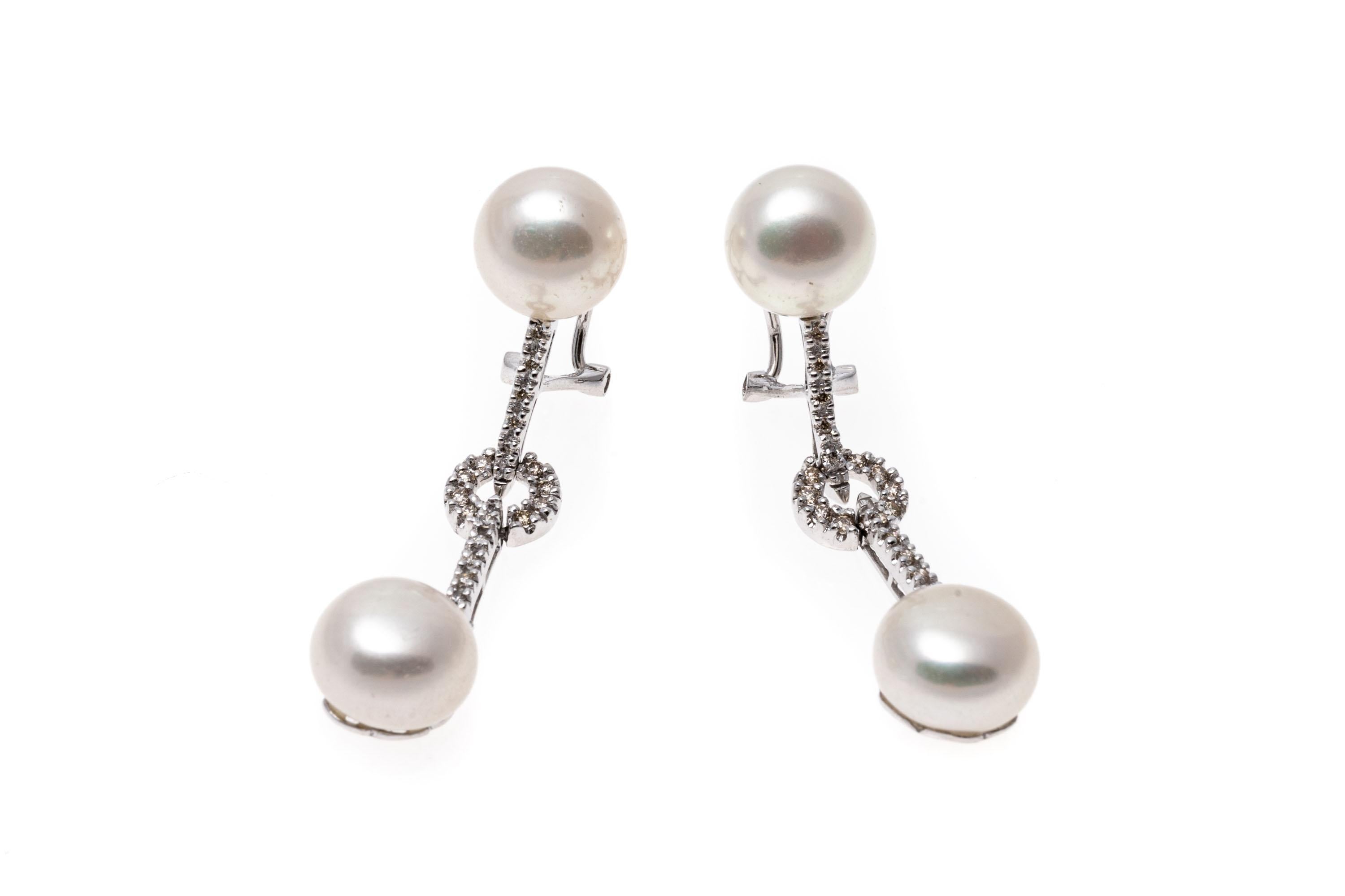 Set with bright white cultured freshwater pearls and diamonds these 14K white gold drop style earrings have an elegant presence. The pearls are approximately 9.0mm and have pink overtones. The diamonds are approximately 0.15 TCW. Post and omega