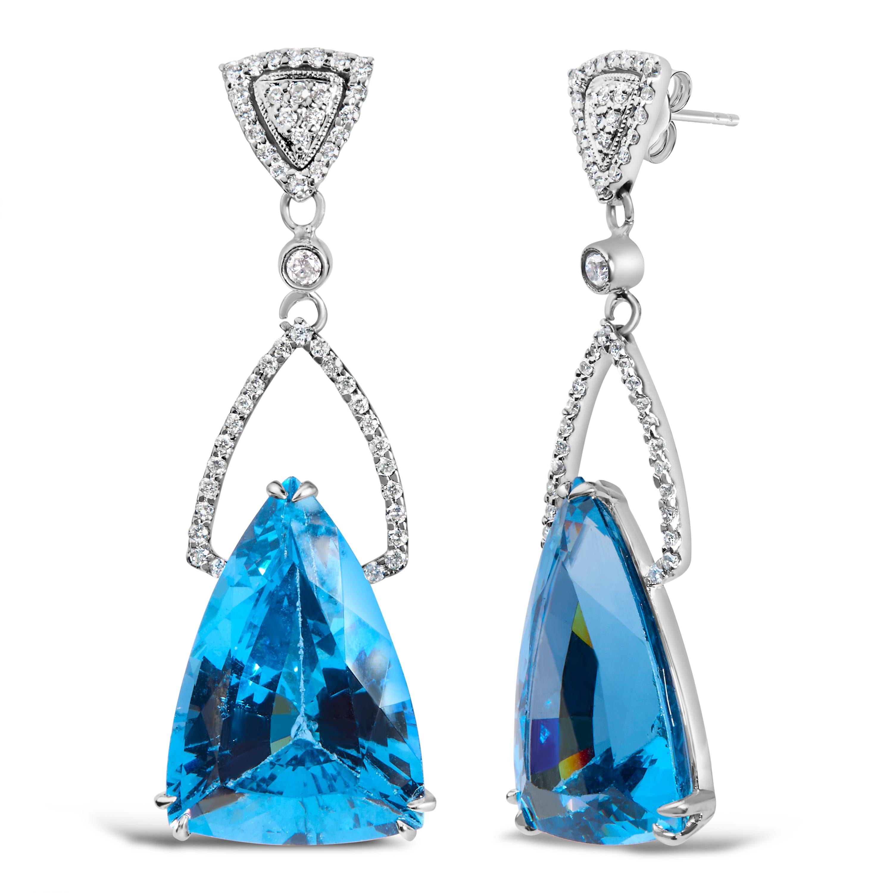Embodying elegance and a shimmering cascade of color, these 14K white gold earrings are a testament to exquisite craftsmanship. Rhodium-plated for an extra touch of radiance, each earring features a spellbinding trillion-cut blue topaz, with its