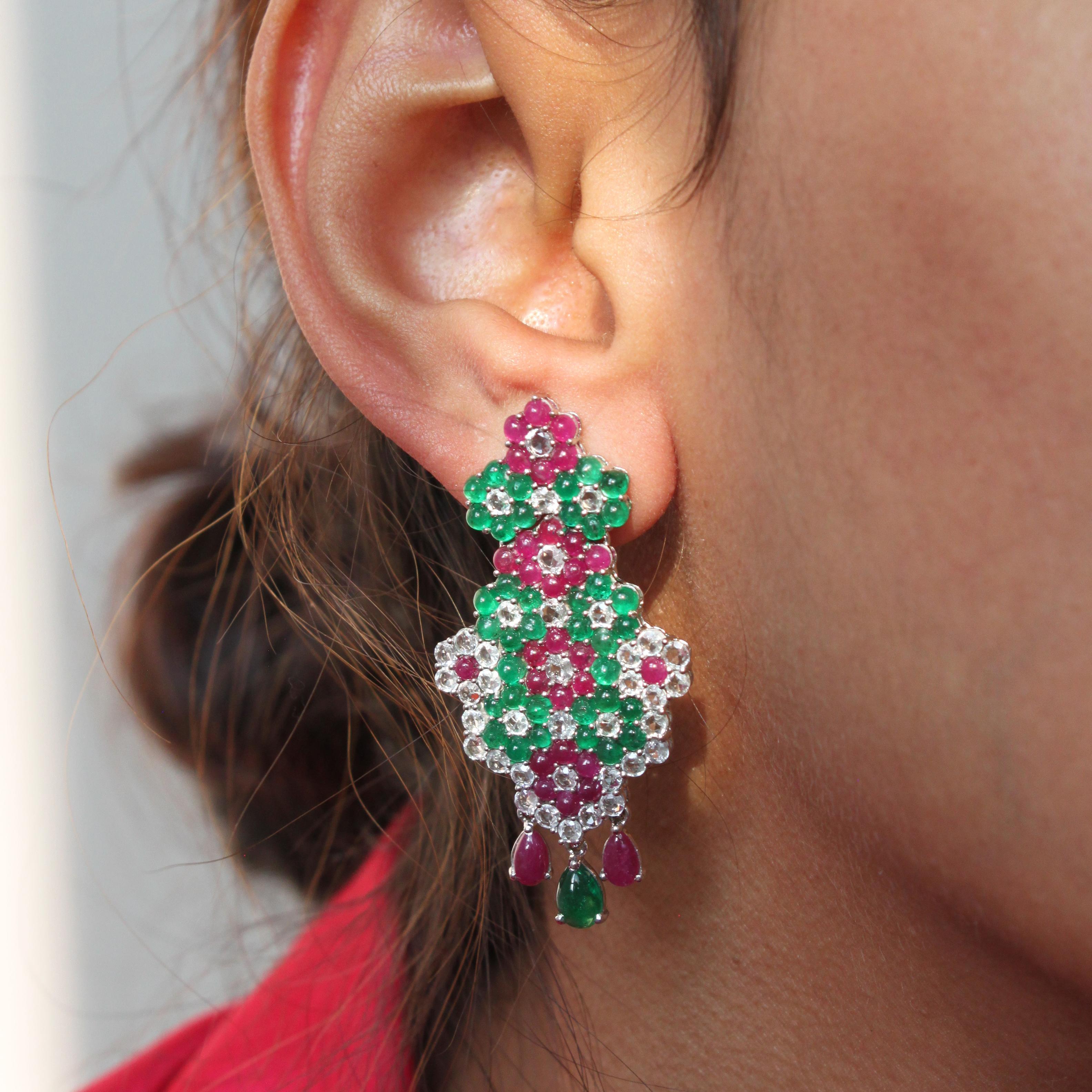 14K white gold
5.56ct natural emerald cabochon
5.25ct natural ruby cabochon
3.7ct natural white sapphire
Total earring weight 15.40g

A pair of dazzling earrings crafted from 14K white gold and adorned with precious gemstones. The earrings feature