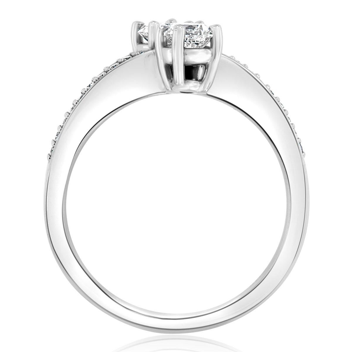 This elegant ring features two perfectly matched 1/3 of a carat each round brilliant diamonds four prongs set on each side of a wavey band. A row of 25 round melee diamonds is micro-prong set on top of the band separating the two larger diamonds.