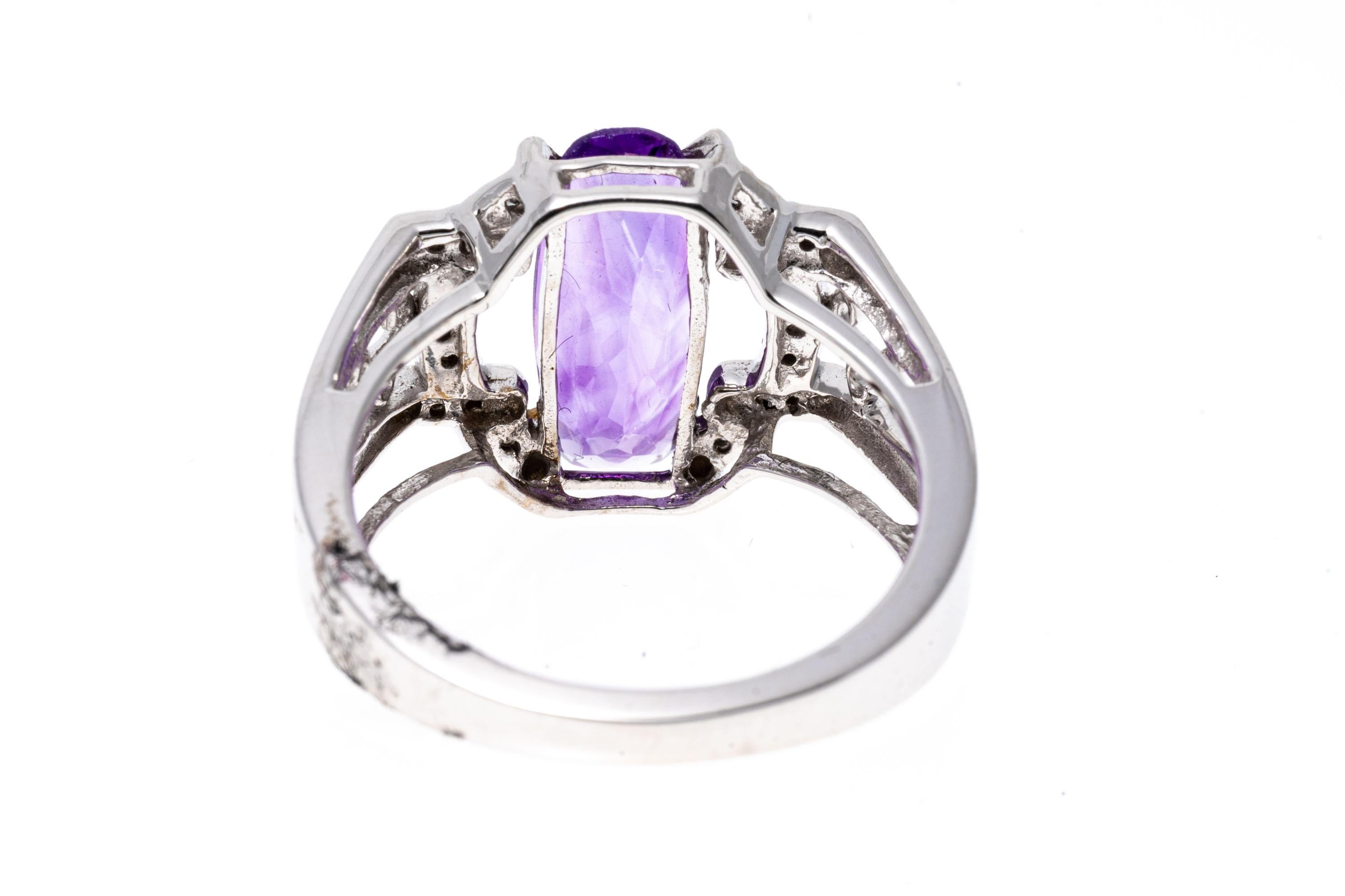 14k white gold ring. This pretty ring has an elongated, narrow oval faceted, light purple color amethyst, approximately 1.90 CTS, and prong set into an open architectural style frame, set with accent diamonds, approximately 0.04 TCW. The ring is