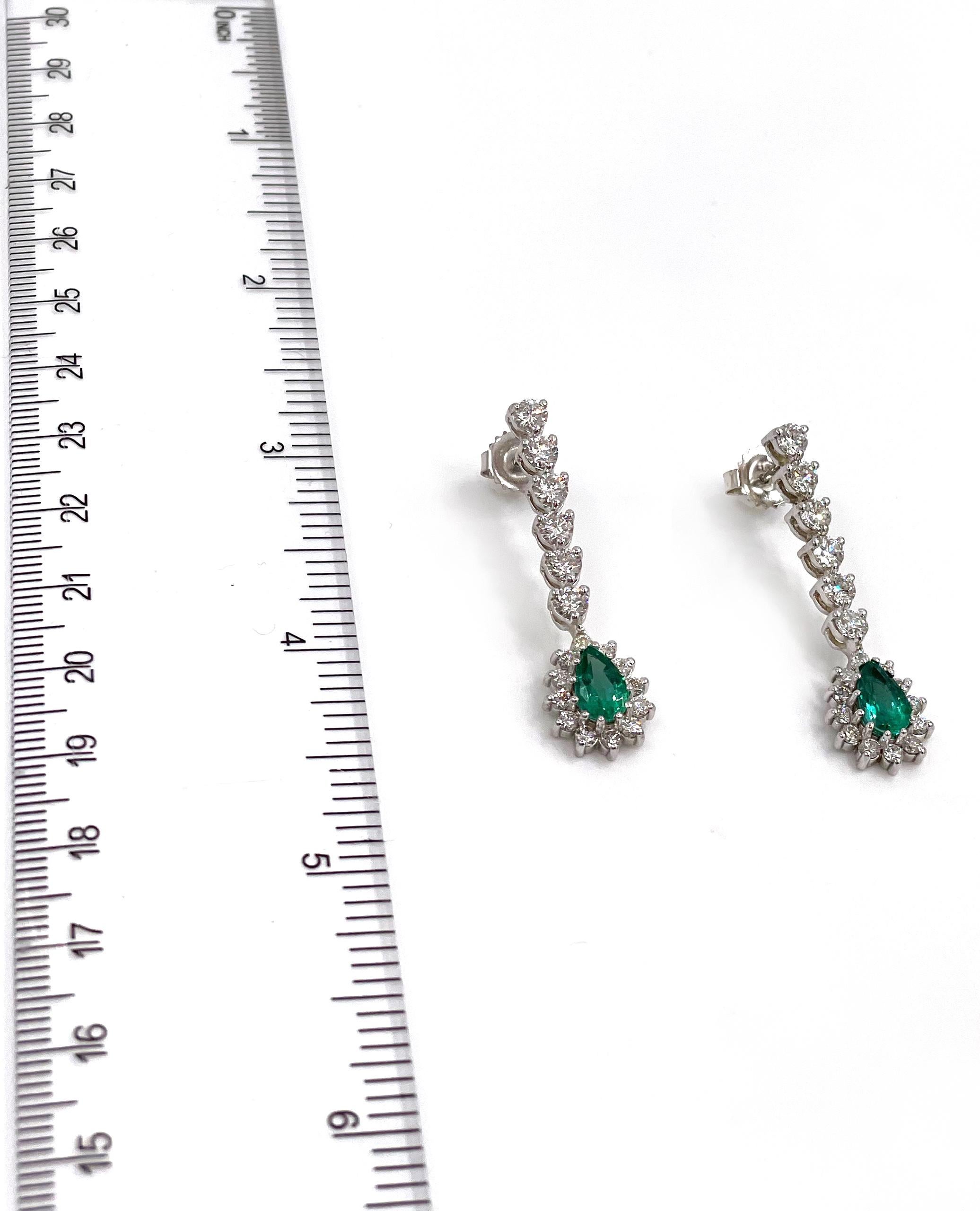 14K white gold long drop earrings with 36 round brilliant-cut diamonds 2.56 carats total weight and two pear shaped emeralds 1.71 carats total weight.

* Diamonds are G/H color, VS2/SI1 clarity.
* Push back closure.