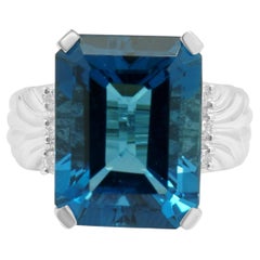 Ring aus 14-karätigem Weißgold mit blauem Topas im Smaragdschliff und runden Diamanten als Akzente