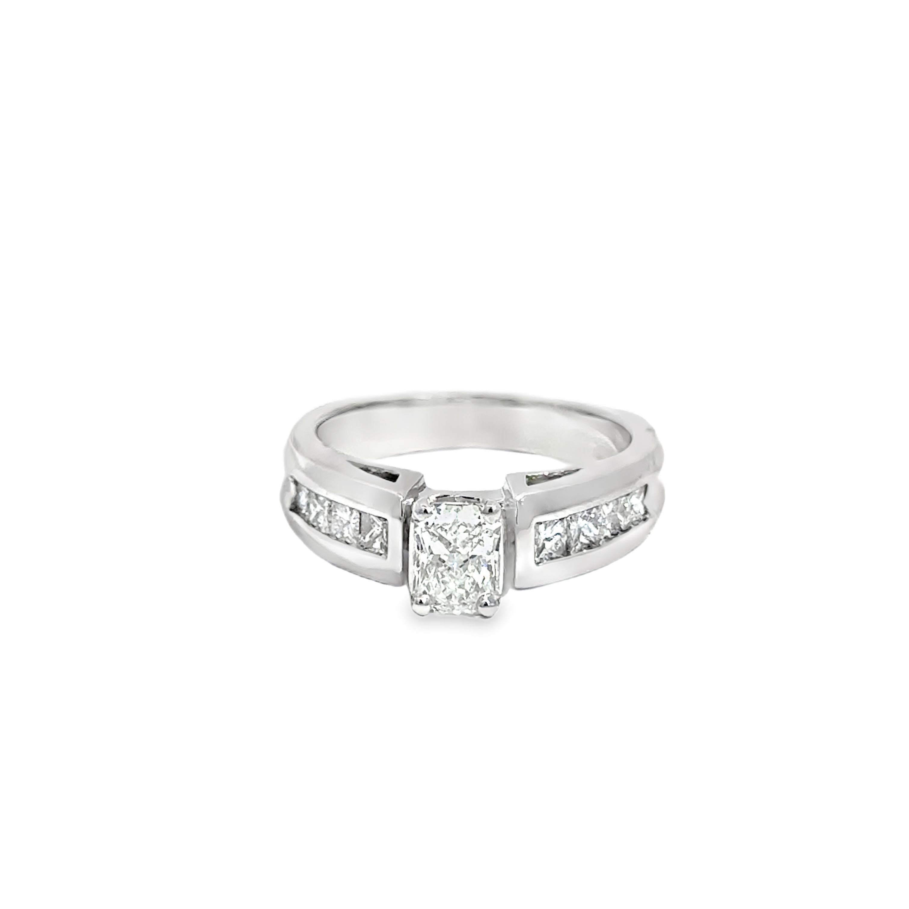 Cette bague moderne et élégante en or blanc 14k est ornée d'un diamant central de 0,68ct de taille émeraude, flanqué de diamants latéraux de taille princesse totalisant 0,88ct. Le design épuré de la bague met l'accent sur des lignes nettes et une