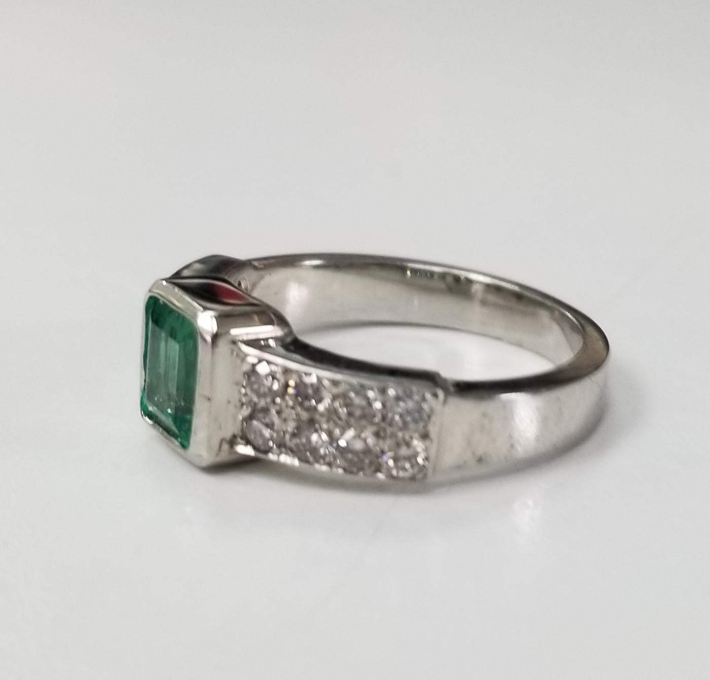Smaragd- und Diamantring aus 14 Karat Weißgold, mit 1 Smaragd im Smaragdschliff mit einem Gewicht von 0,76 ct. und 16 runden Diamanten im Vollschliff von sehr guter Qualität mit einem Gewicht von 0,55 pt.  Dieser Ring ist eine Größe 6,5, aber wir