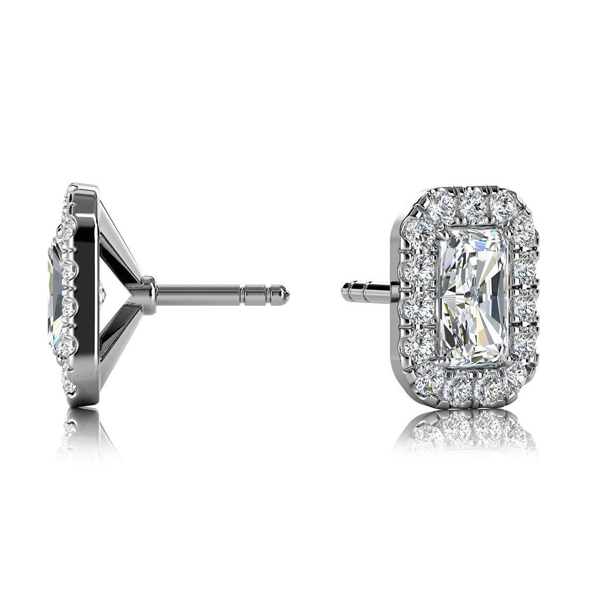 Ces délicates boucles d'oreilles comportent deux diamants de forme émeraude d'un poids total d'environ 0,60 carat (5 mm x 3 mm) entourés d'un halo de 30 diamants ronds de taille brillant parfaitement assortis d'un poids total d'environ 0,40 carat.