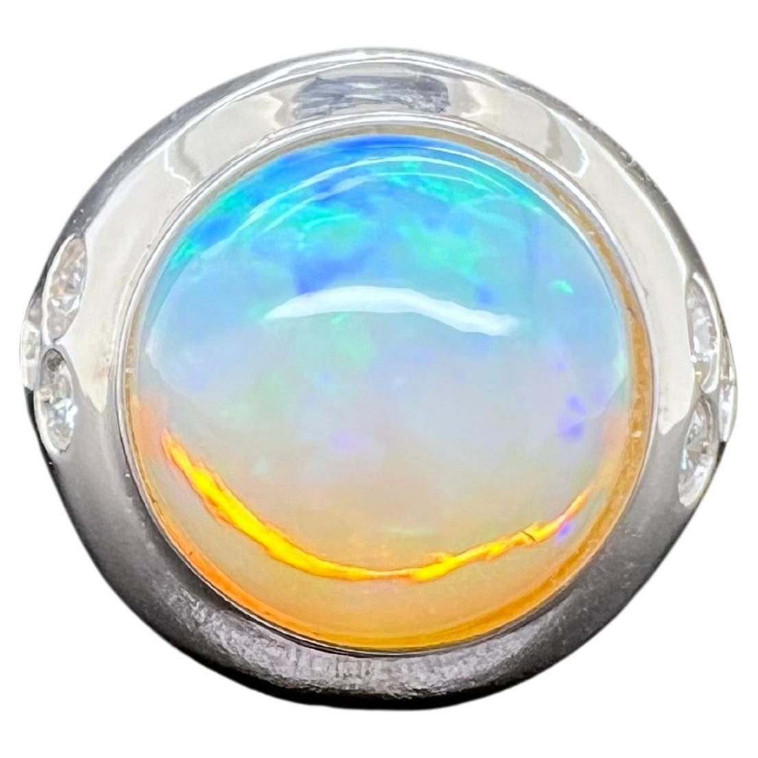 This stunning Ethiopian opal men's ring is a must have for any collection. The round opal glows with green, blue and yellow hues. The diamonds are inlayed on the sides to give a nice accent to the sleek ring. The overall design of the ring is made