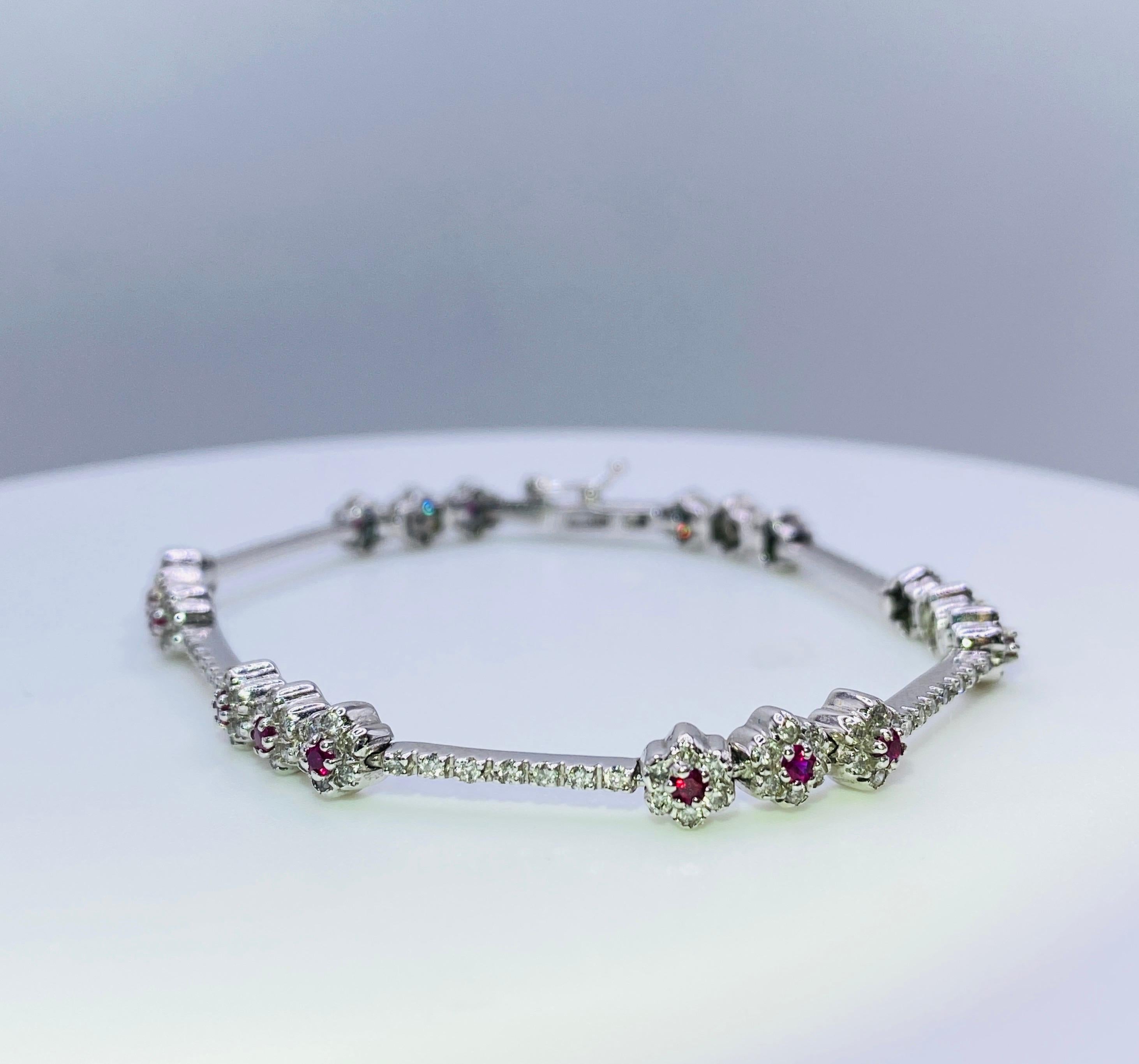 14K white gold flower line bracelet with 18=0.80 carat total weight round brilliant rubies and 150=1.68 carat total weight round brilliant diamonds. Length 7”