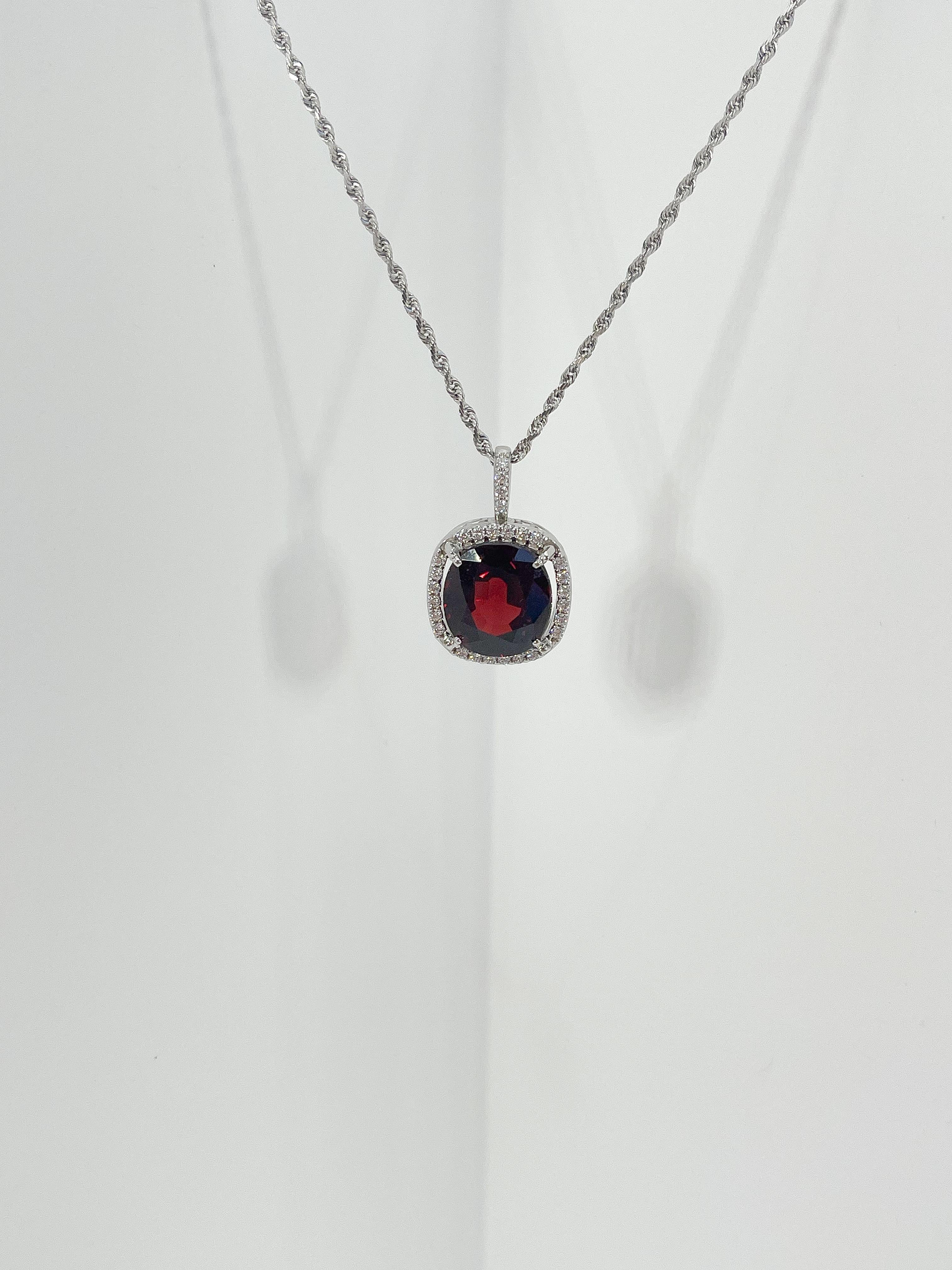 14k white gold garnet and .33 CTW diamond halo pendant necklace. The garnet is cushion shaped and measures to be 10.7mm x 10.7mm, the diamonds in the halo and the bail are all round, pendant comes on an 18 inch diamond cut rope chain, and the