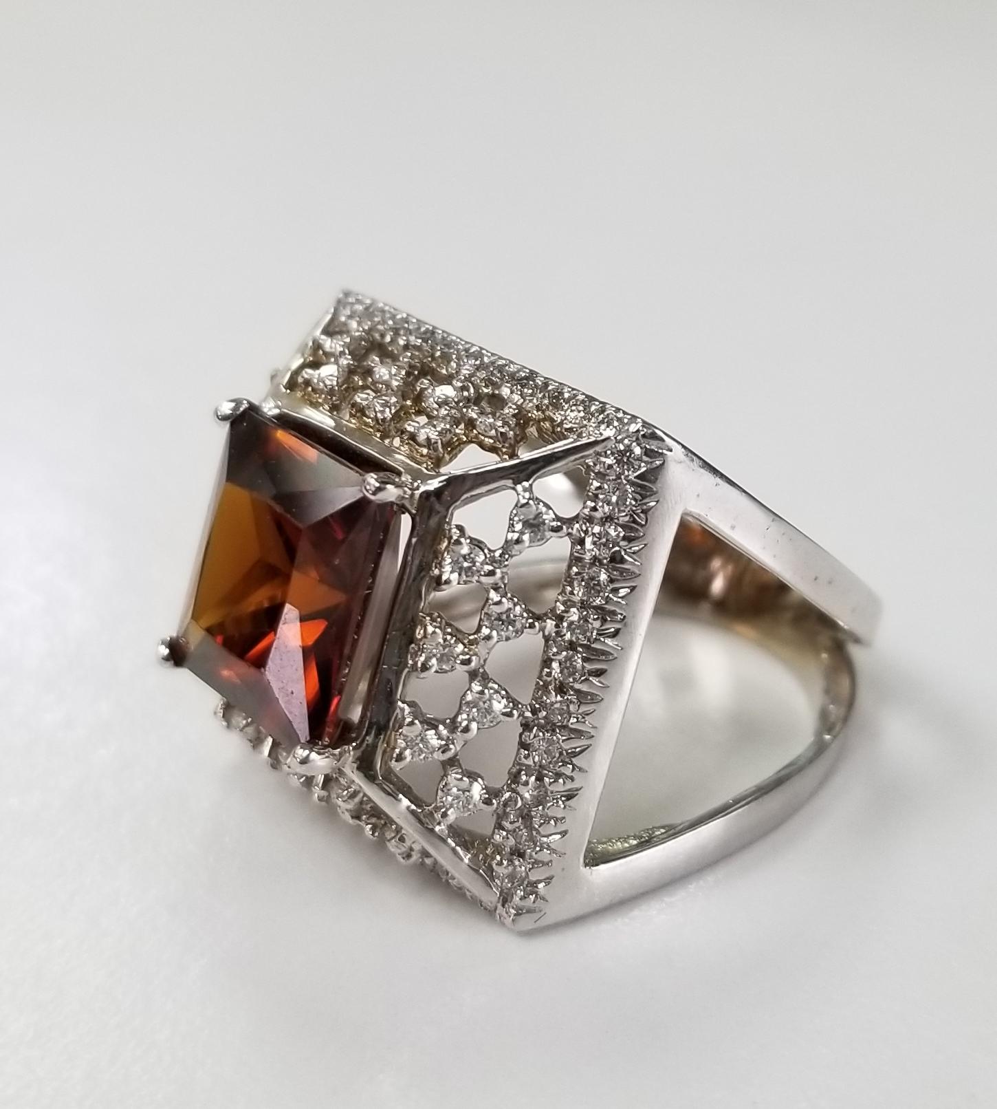 14k white gold Garnet and diamond ring, containing 1 square cut garnet weighing 6.25cts. and 72 round full cut diamonds of very fine quality weighing .70pts. set in a tiered setting.  This ring is a size 6.5 but we will size to fit for free.