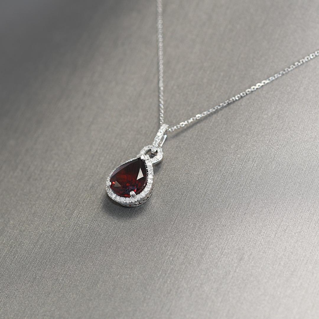Ladies garnet and diamond pendant necklace in 14k white gold setting.

Stamped 14k and weighs 2.7 grams gross weight.

The garnet is a pear shape, approximately 2.90 carats, attractive reddish color.

The garnet is surrounded by small round diamonds