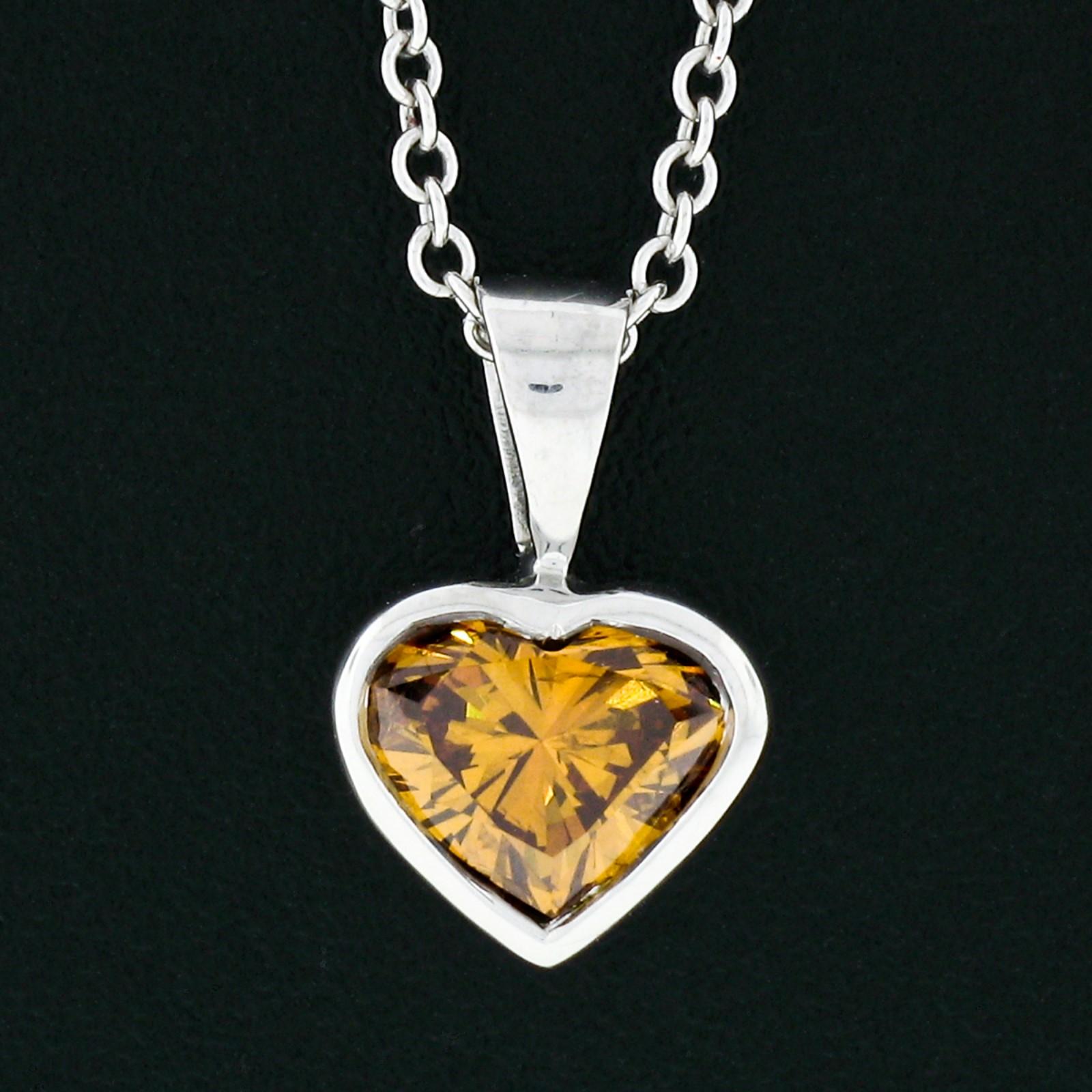 This stunning heart diamond pendant is crafted in solid 14k white gold and features a gorgeous GIA certified diamond weighing exactly 0.70 carats. The diamond has a natural and even fancy deep brown-orange color and is beautifully and neatly bezel