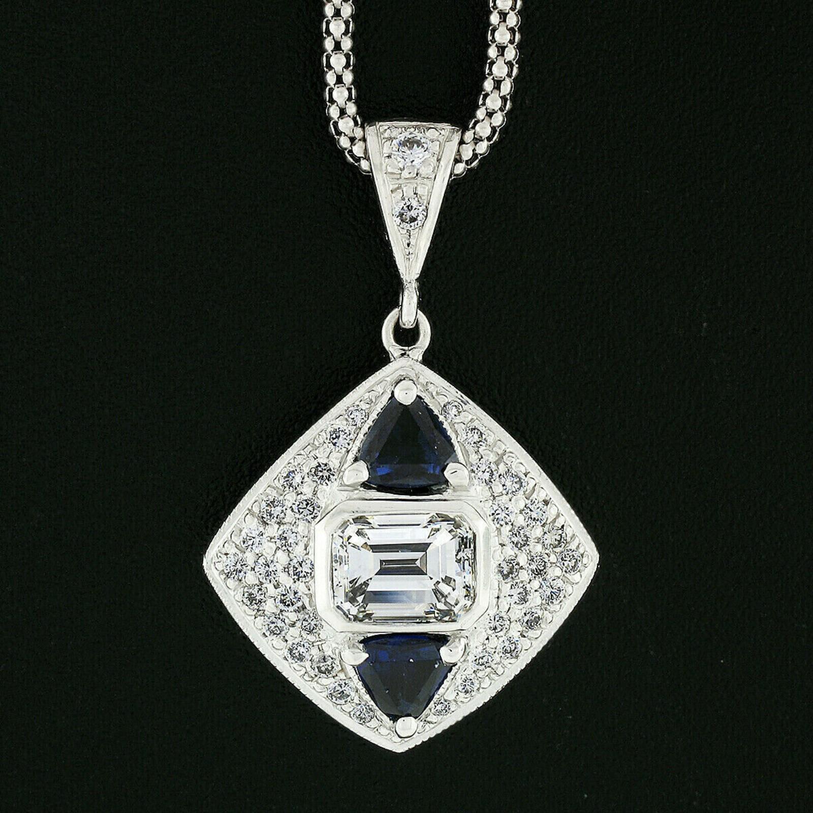 Here we have a magnificent diamond and sapphire pendant that was crafted from solid 14k white gold. It features a gorgeous GIA certified emerald cut diamond weighing exactly 1.02 carats. The diamond is very fine quality with near-colorless I color