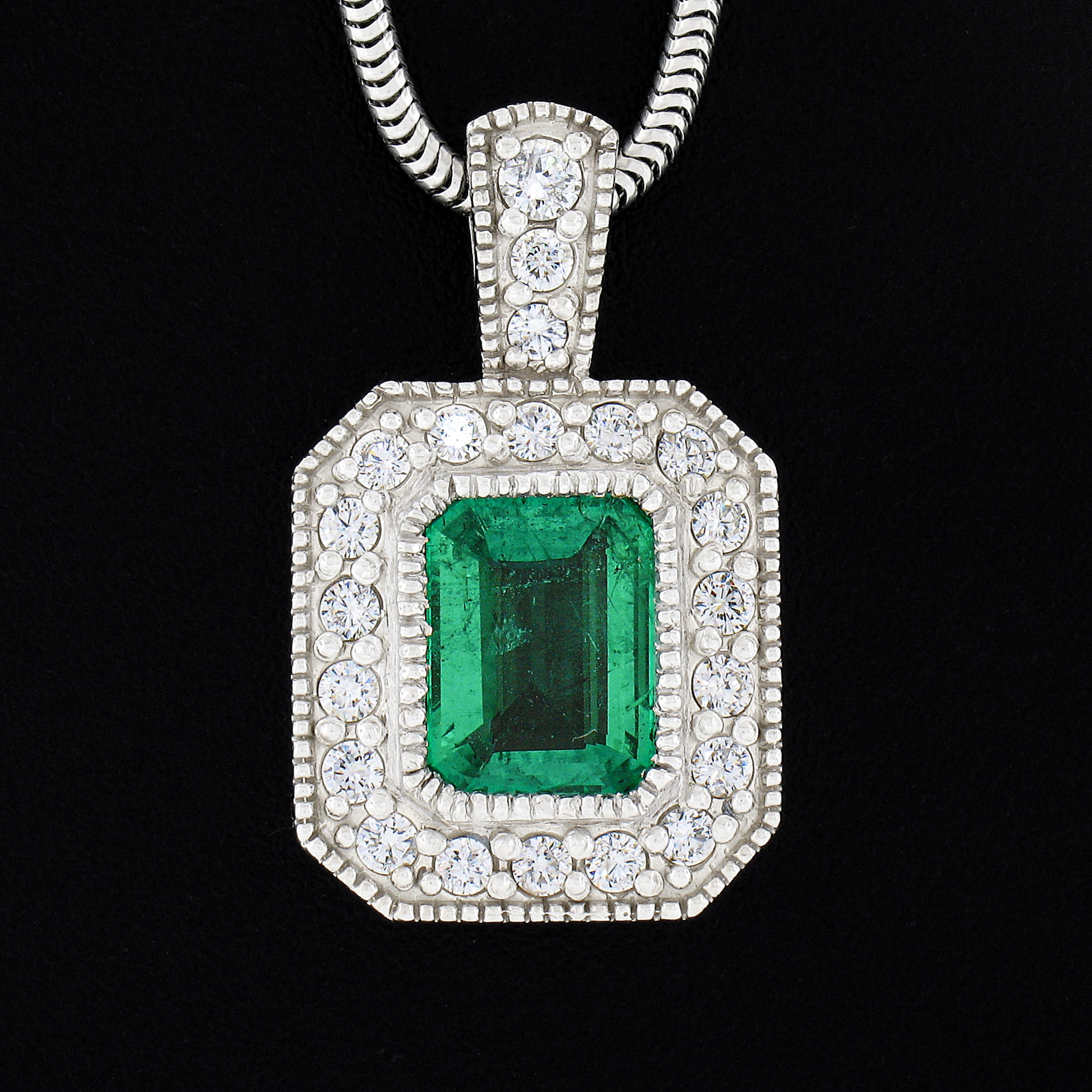 Here we have an absolutely magnificent and truly jaw dropping pendant that is crafted from solid 14k white gold that carries a gorgeous, GIA certified, natural emerald stone surrounded by a super fiery diamonds throughout. The incredible center