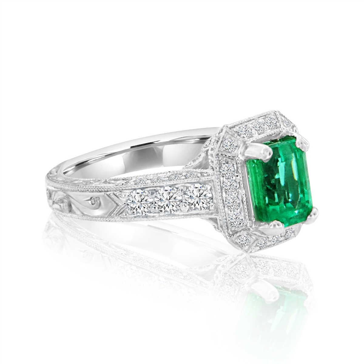 This vintage style stunning ring features one 1.43 carat Emerald Shape vibrant green emerald set in a halo-designed crown. This ring is luxurious with a hand touched details, from a delicate touch of milgrain design throughout the halo crown to