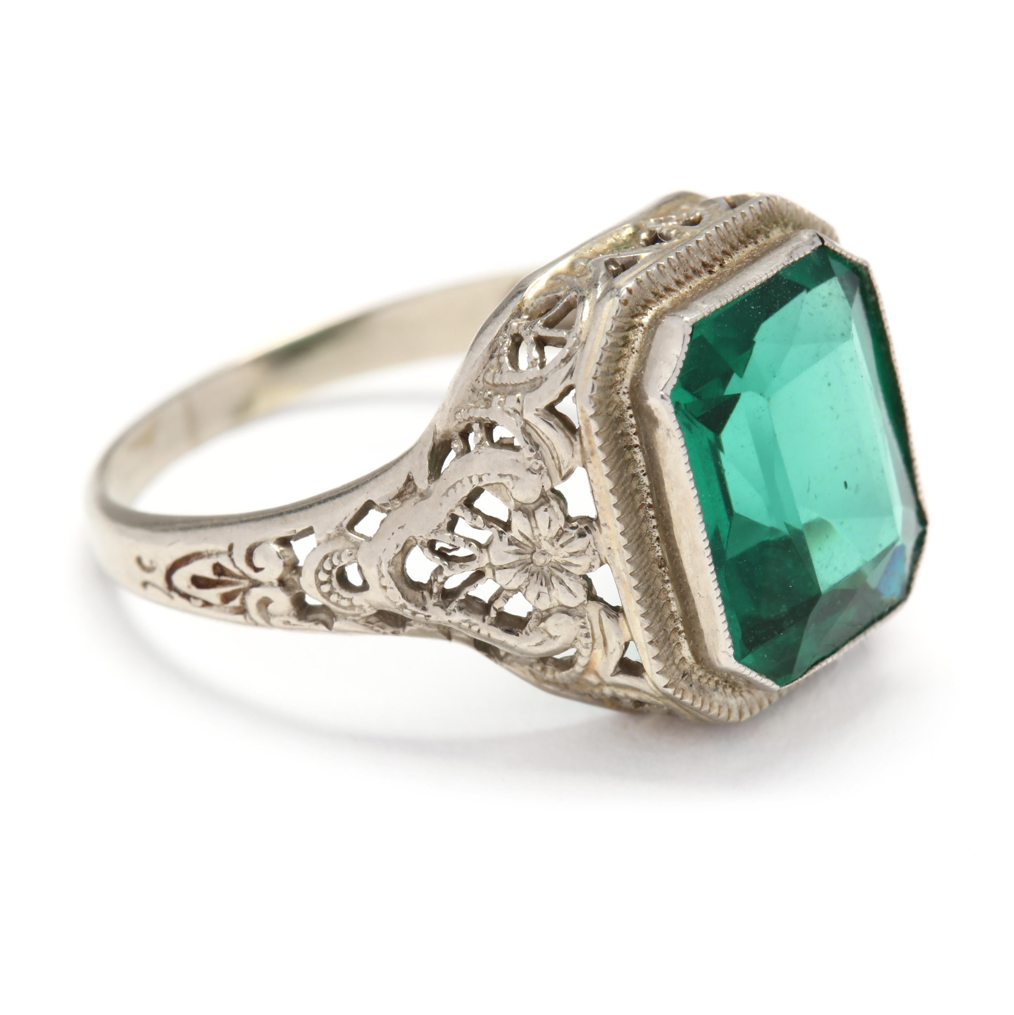 Filigraner Vintage-Ring aus 14 Karat Weißgold und grünen Steinen. In der Mitte befindet sich ein grüner Stein im Smaragdschliff:: der in einer floralen:: filigranen Fassung mit einer sich verjüngenden Halterung gefasst ist. 

Steine: 
- grüner