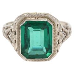 filigraner Ring aus 14 Karat Weißgold und grünen Steinen