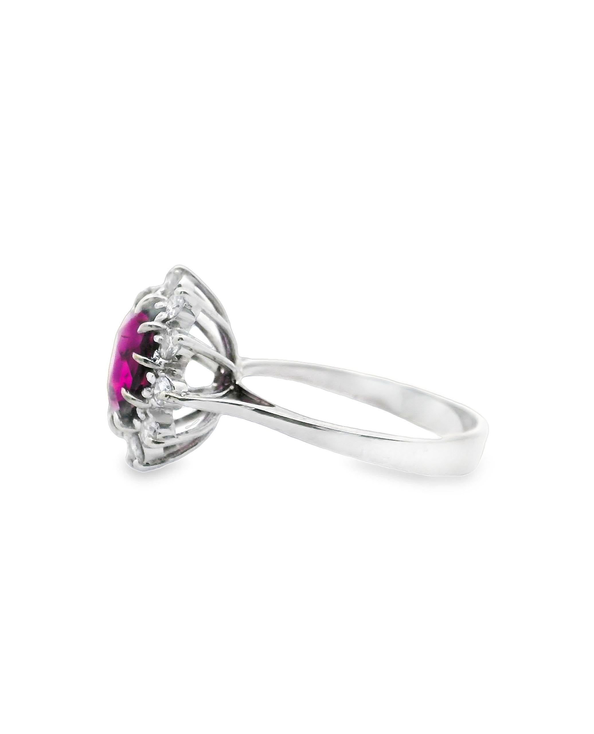 14K white gold ring featuring one center round faceted rhodolite measuring approximately 9mm in diameter. The rhodolite is surrounded by 12 round brilliant-cut diamonds weighing 0.60 carats total weight. 

- Finger size 7
- The diamonds are G color,