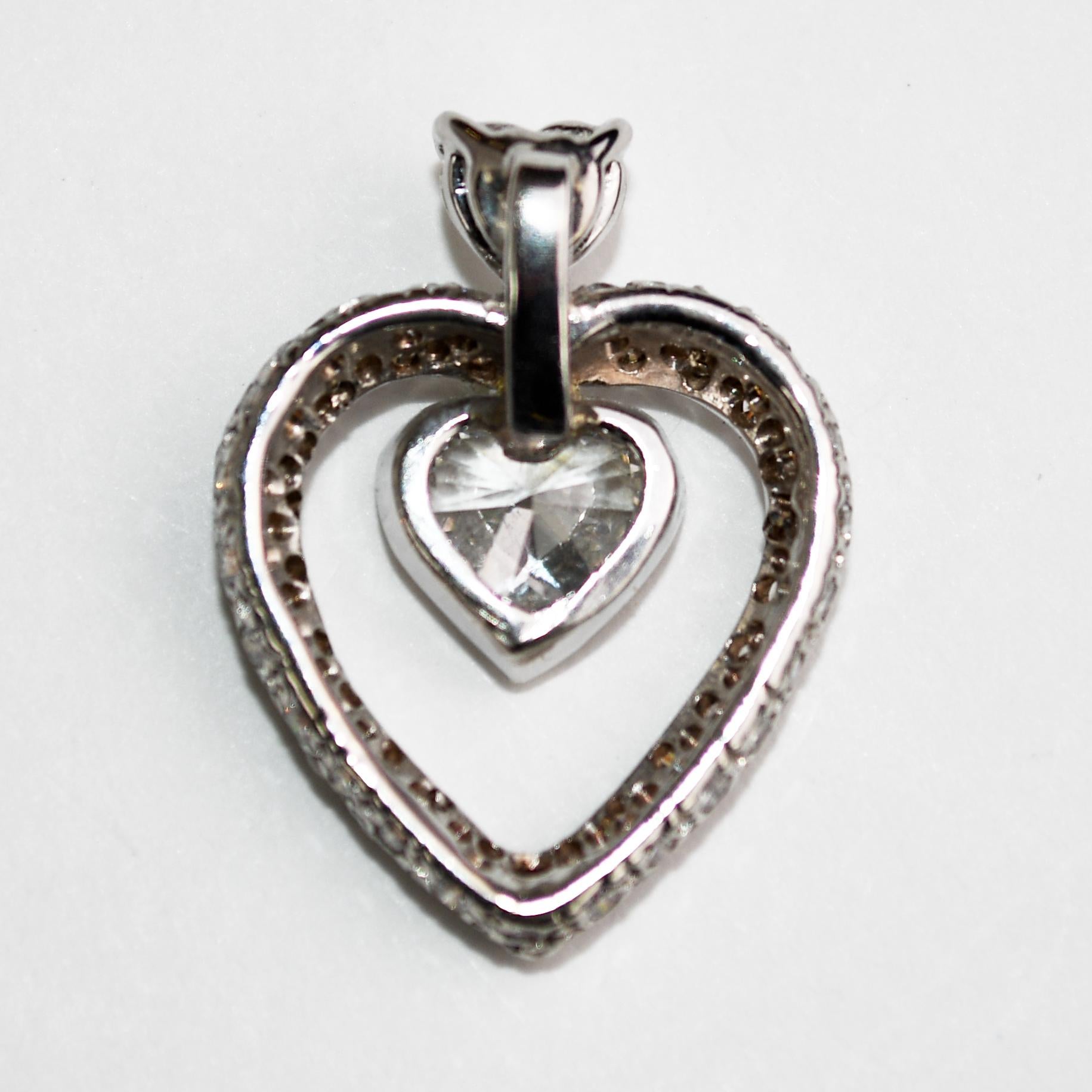 Ciondolo a cuore con diamante e montatura in oro bianco 14k.
Test del 57.5% di oro con un analizzatore di metalli XRF.
Il peso lordo è di 2,2 grammi.
Il diamante centrale è a forma di cuore, 0,60 carati, colore da H a I, purezza Vs.
C'è un cuore da
