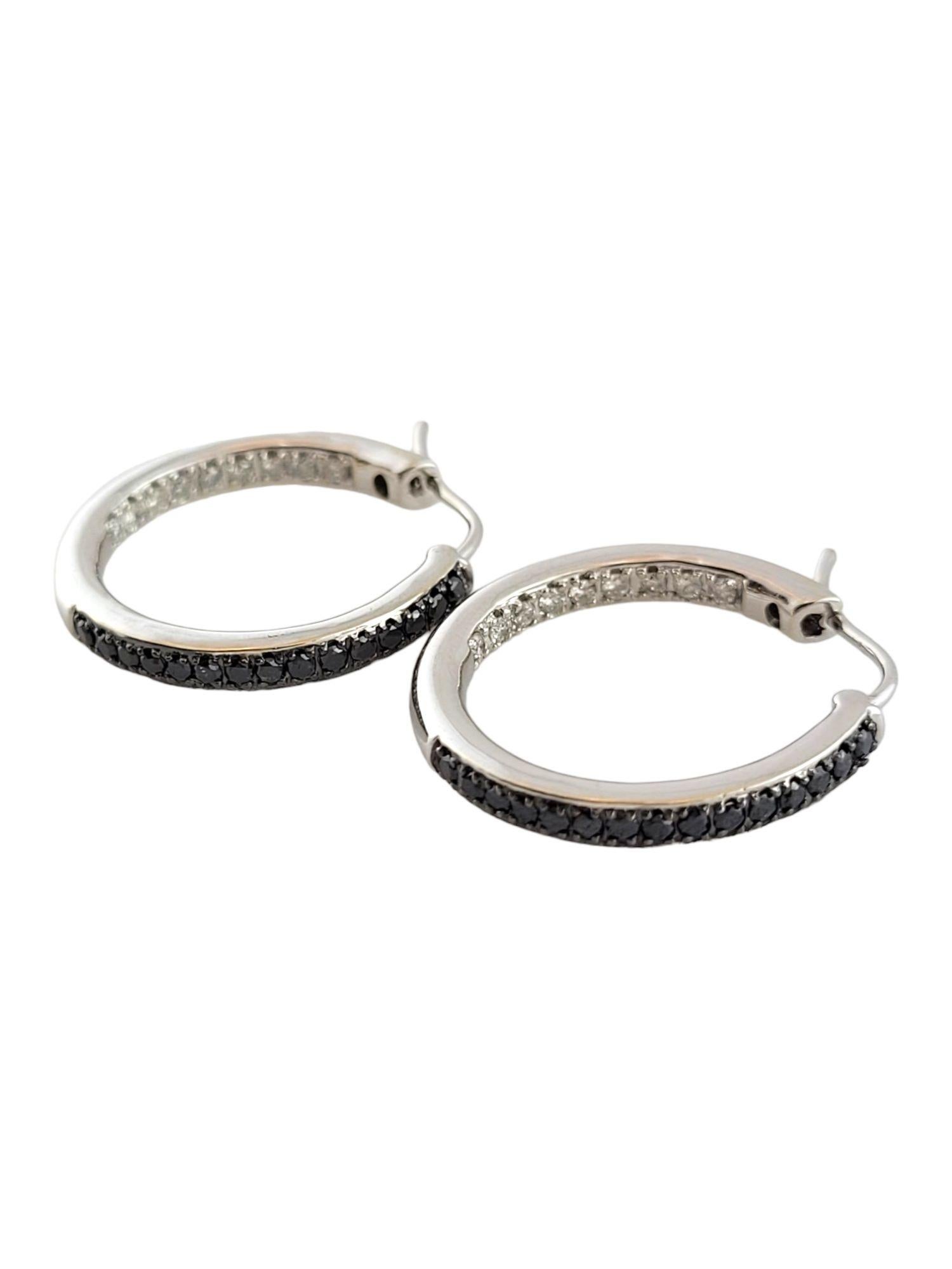 This gorgeous set of white gold hoops has a unique design that features 15 black diamonds on the outside and 9 white, round cut diamonds on the inside of each earring. (30 Back diamonds total) (18 white diamonds total)

Approximate total diamond